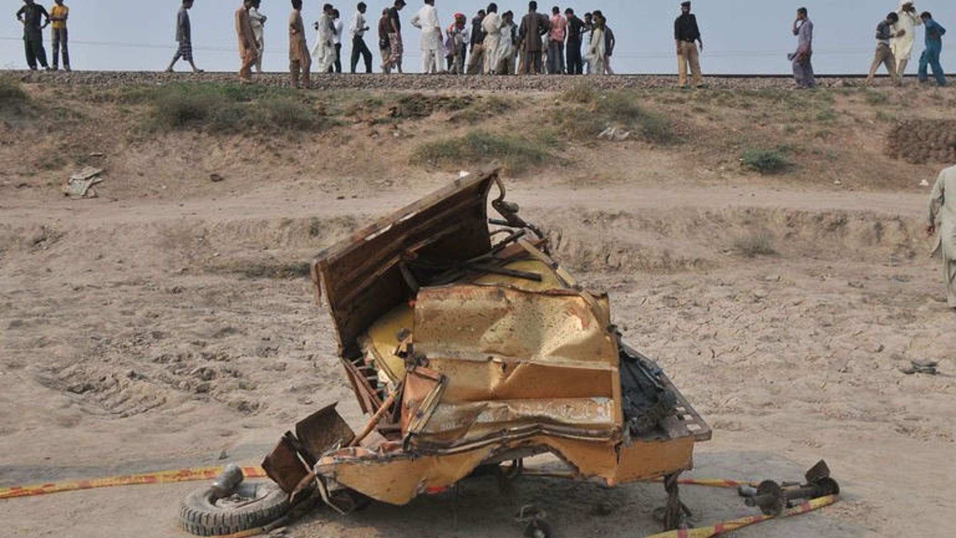 The mangled wreckage of a motorcycle rickshaw after a train collided with it in Khanpur town, Punjab province, on July 6, 2013. At least 14 people, including two children, were killed in the crash.
