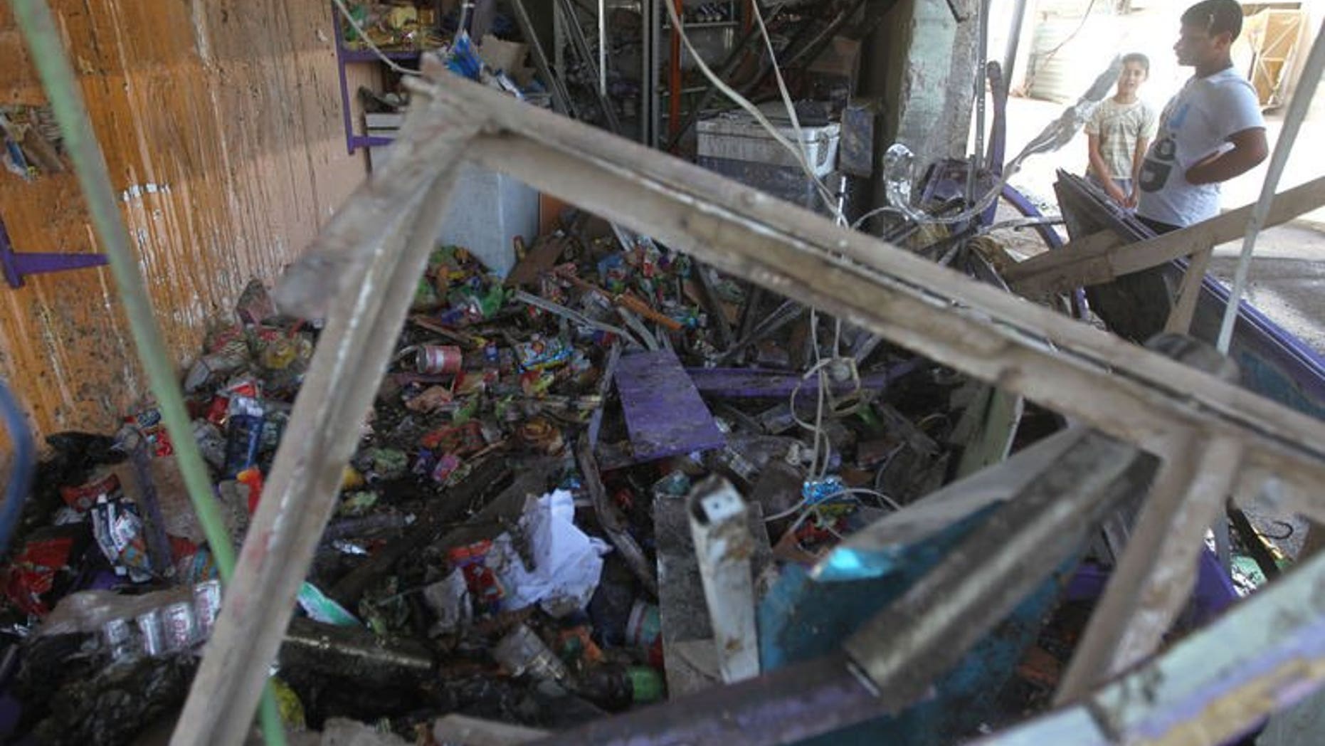 A man looks at a destroyed shop following a car bomb in the Shuala area of eastern Baghdad, on July 3, 2013. Bombings north of Baghdad on Saturday killed five people, including a police officer, police and doctors said, a day after attacks across the country left 23 dead.