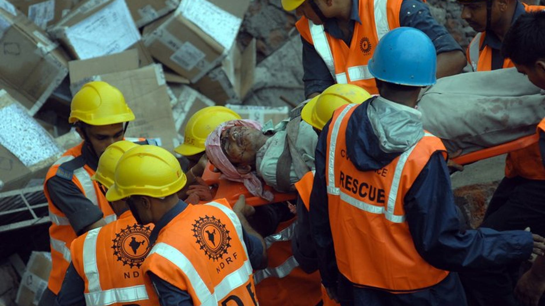 Rescue personnel move an injured worker from the rubble of a collapsed building in Mumbai on July 4, 2013. A two-storey hotel collapsed in the southern Indian city of Secunderabad, killing five restaurant workers and injuring 15 others.