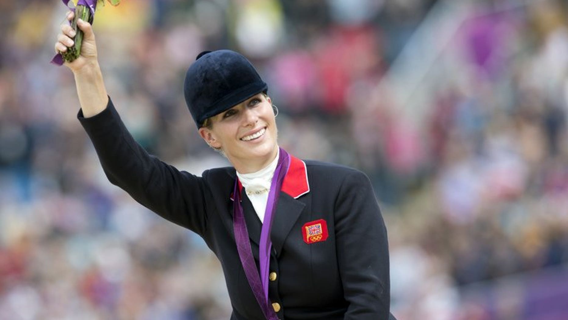 Queen Elizabeth II's eldest granddaughter Zara Tindall, previously known as Zara Phillips, waves to the crowd after winning the silver medal in the team equestrian event at the 2012 London Olympics in Greenwich Park, London on July 31, 2012. Tindall and her rugby player husband Mike Tindall are expecting their first child at the beginning of next year, Buckingham Palace announced on Monday.