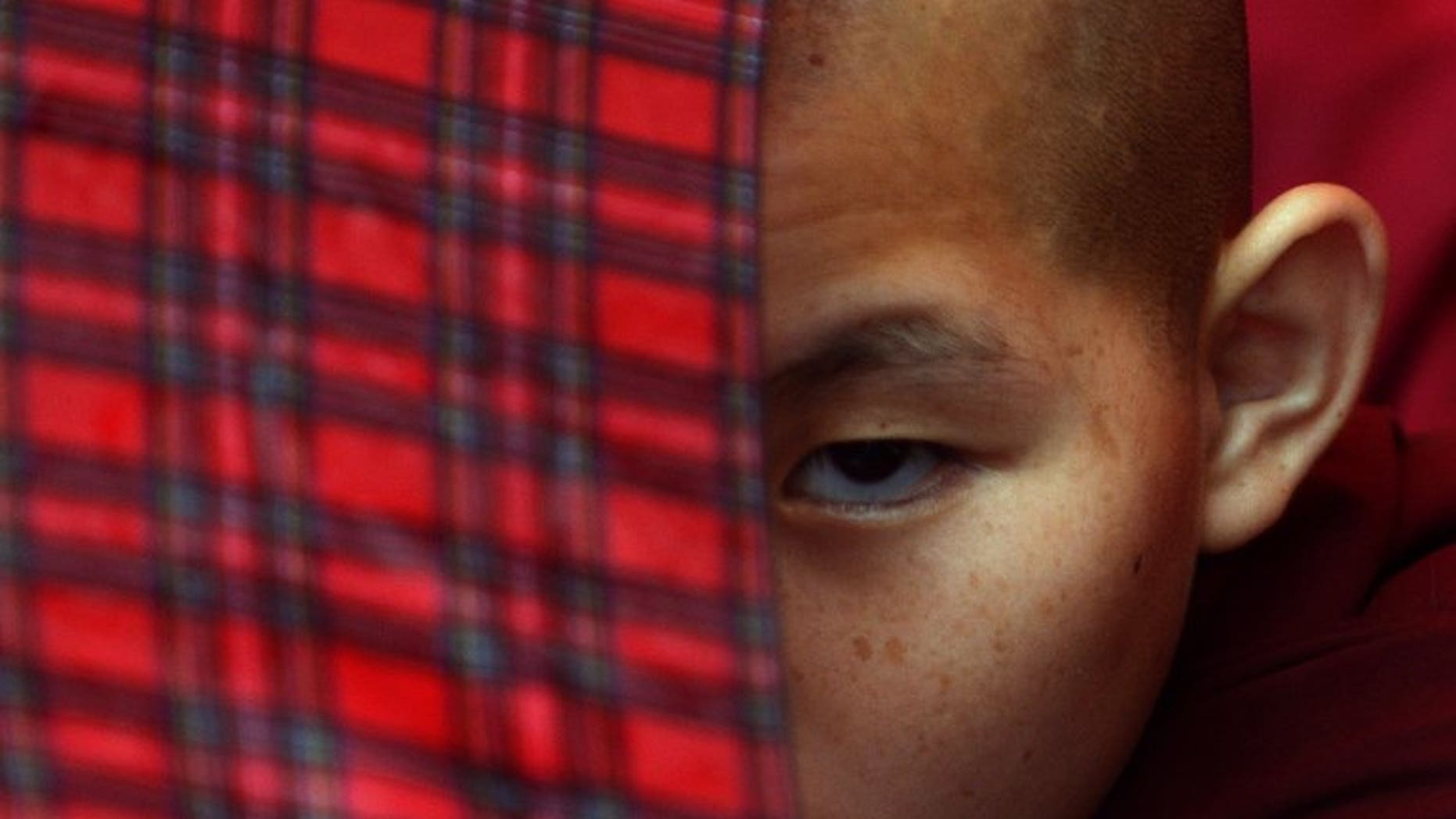 A young exiled Tibetan Buddhist monk watches festivities in Kathmandu on July 6, 2013. Chinese police opened fire on Tibetans marking the Dalai Lama's 78th birthday, shooting at least one monk in the head and seriously wounding several other people, two overseas groups said.