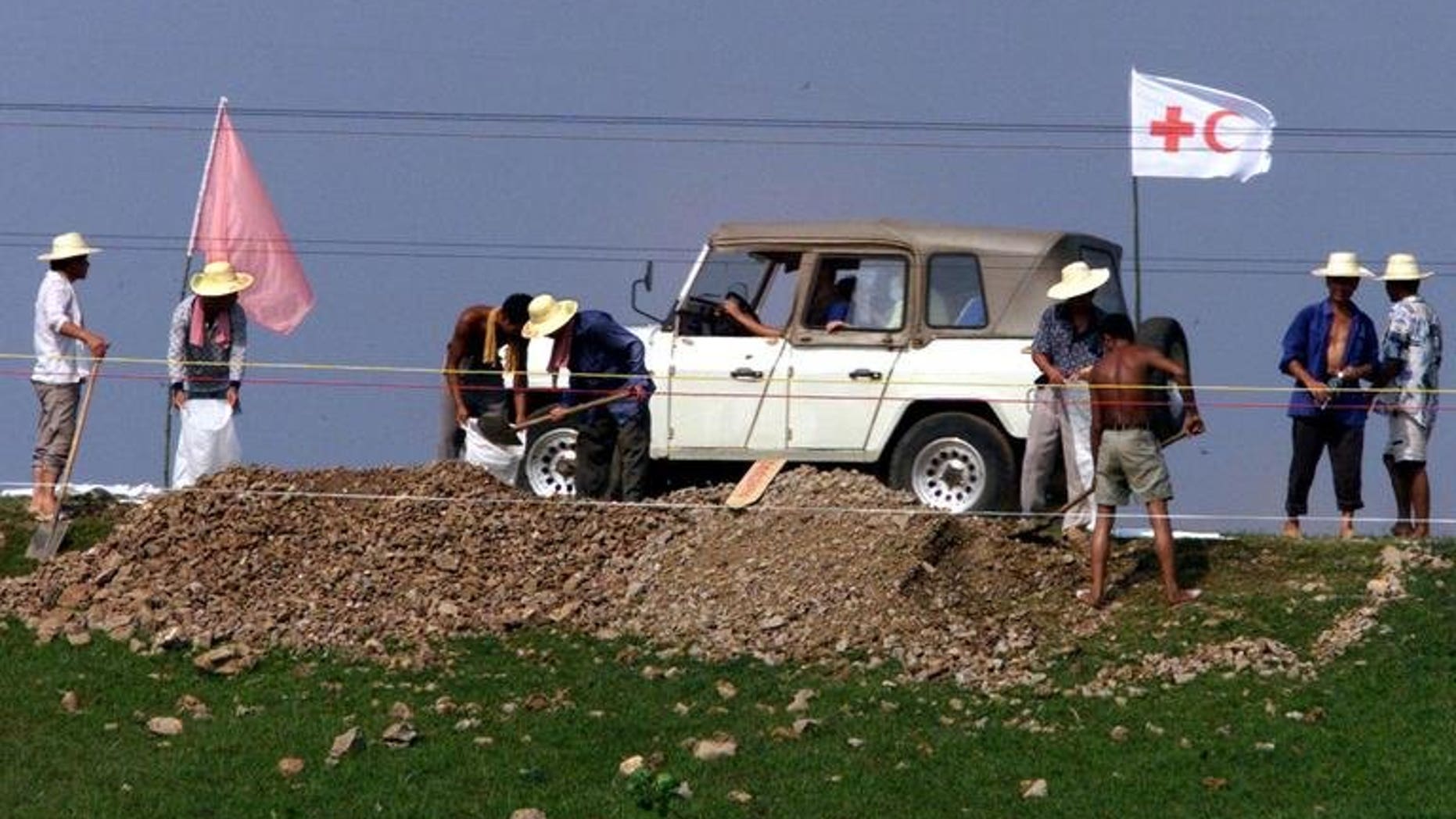 Illustration shows a Red Cross jeep driving past workers near the Yangtze River, China. The Chinese Red Cross demands money from hospitals to help arrange organ donations, media reported Tuesday.