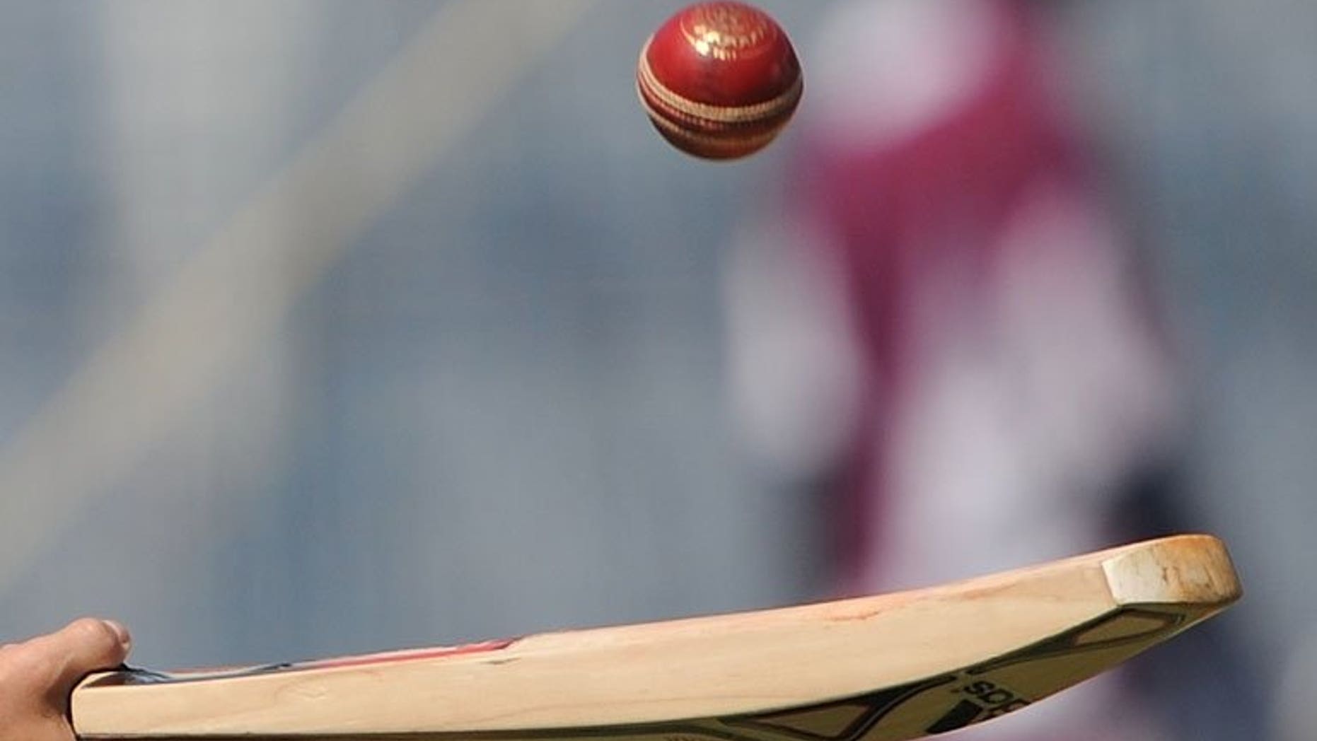 A cricketer tosses a ball with a bat in Mumbai on November 21, 2011. Sri Lanka cricket bosses banned two umpires named by an Indian television programme last year that claimed they were willing to make favourable decisions during matches for cash.