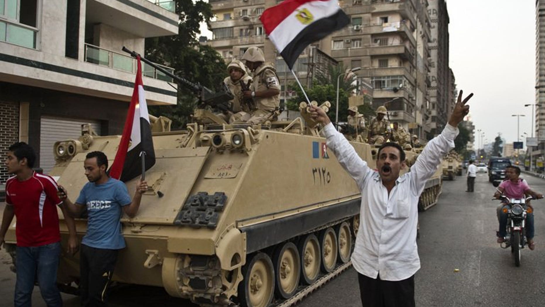 Demonstrators salute army tanks upon their deployment on a street leading to Cairo University on July 3. Amnesty International said on Wednesday it had evidence pointing to the "disproportionate" use of lethal force by Egyptian security forces, and called for them to be reined in to avoid "disaster".