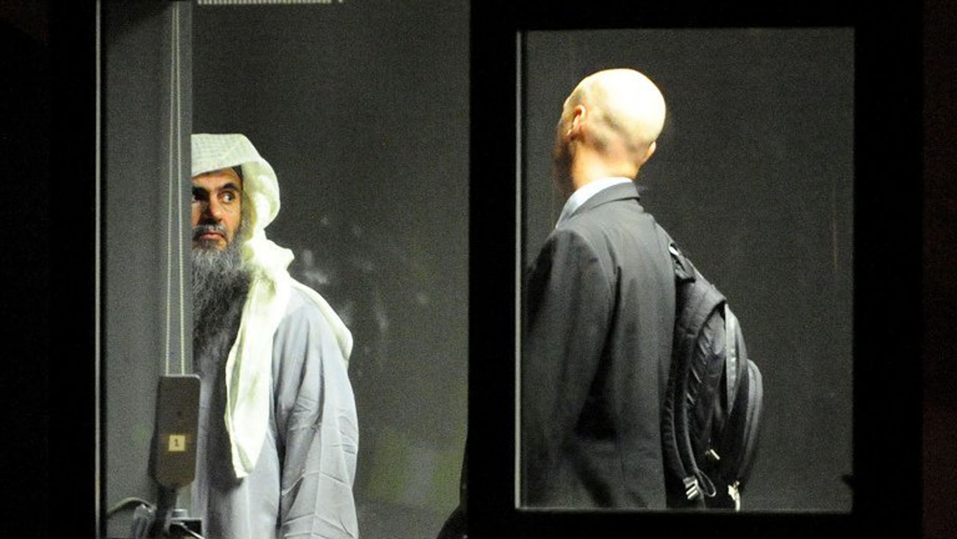 A photo release by the Home Office shows Abu Qatada waiting with an escort to board a jet at RAF Northolt, west London, on July 7, 2013. A military court has postponed until next week a bail application by the Islamist cleric, who faces terror charges in Jordan following his deportation from Britain.
