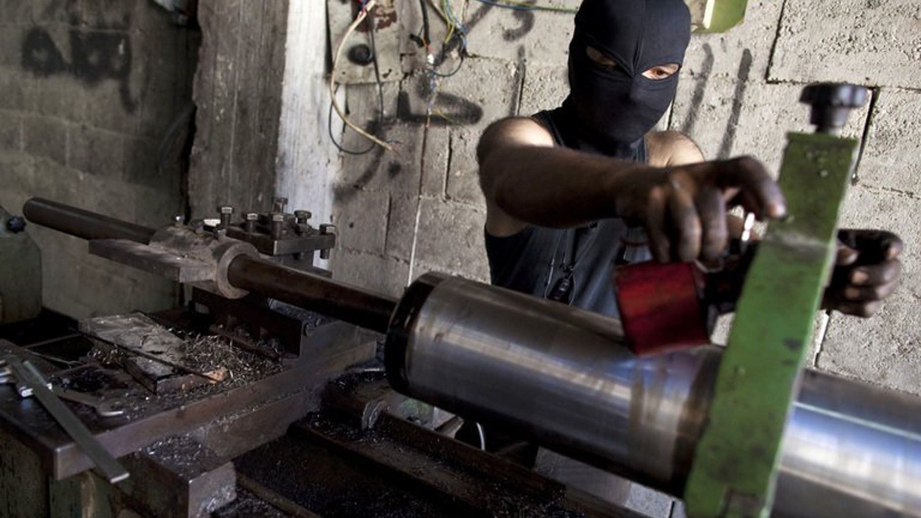 A man assembles an improvised cannon to be used by rebel fighters, at a factory in Syria's Aleppo city, on July 7, 2013. Islamic extremists fighting in Syria pose one of the most worrying threats to Britain and its allies, particularly if they gain access to the regime's stocks of chemical weapons, parliament's intelligence committee says.