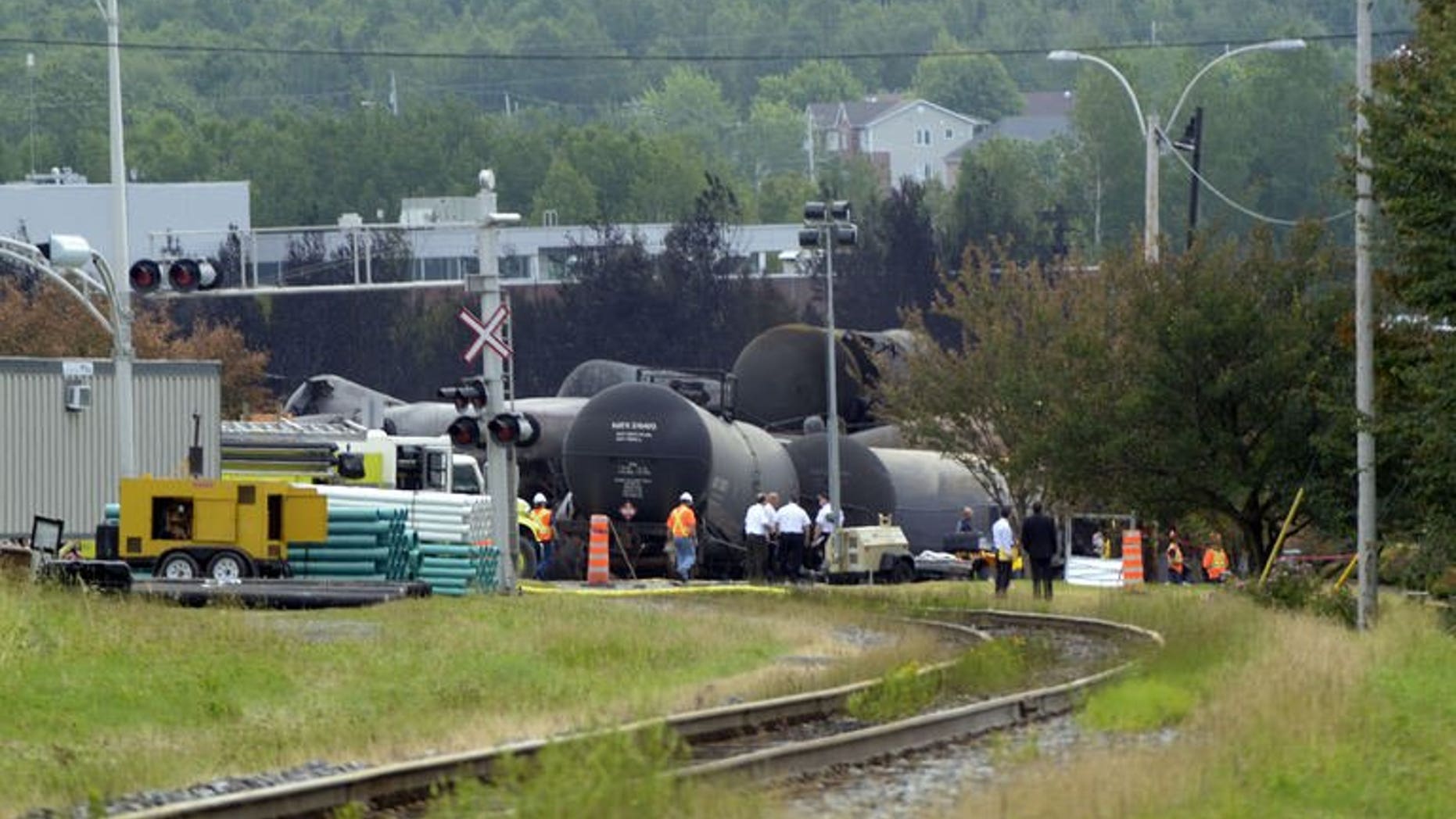 Investigators work at the train derailment site July 9, 2013 in Lac-megantic, Quebec, Canada. The disaster that "probably" killed as many as 50 people was likely the result of an engineer's failure to set the brakes on an unmanned train owned by a US railway company, officials said.