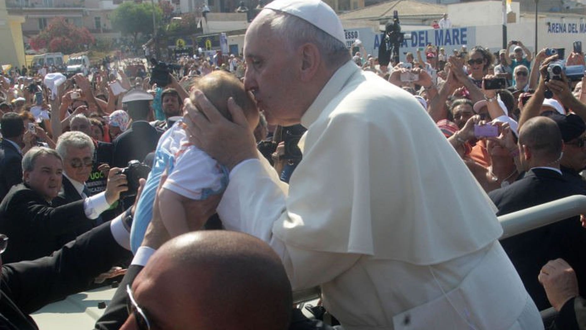 Pope Francis blesses a child during his visit to the island of Lampedusa, a key destination of tens of thousands of would-be immigrants from Africa, on July 8, 2013. Vanity Fair in Italy on Wednesday named Pope Francis its "man of the year", saying the pontiff's first 100 days at the Vatican had already made him one of the world's top leaders.
