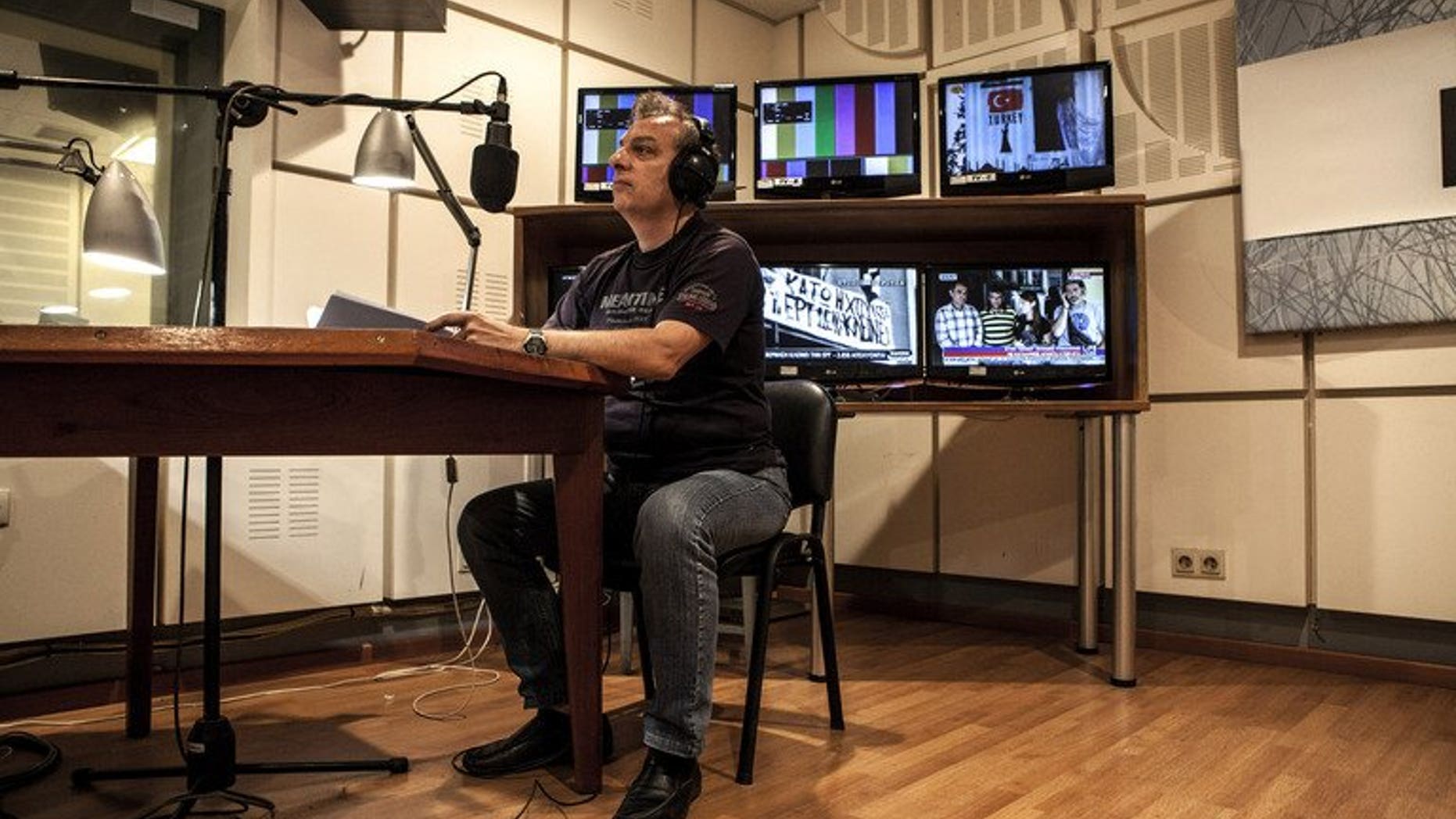 A worker at Greek state broadcaster ERT edits a news bulletin, in Athens on July 10, 2013. The network went back on air, one month after the government abruptly pulled the plug on state broadcaster ERT causing national and international uproar.