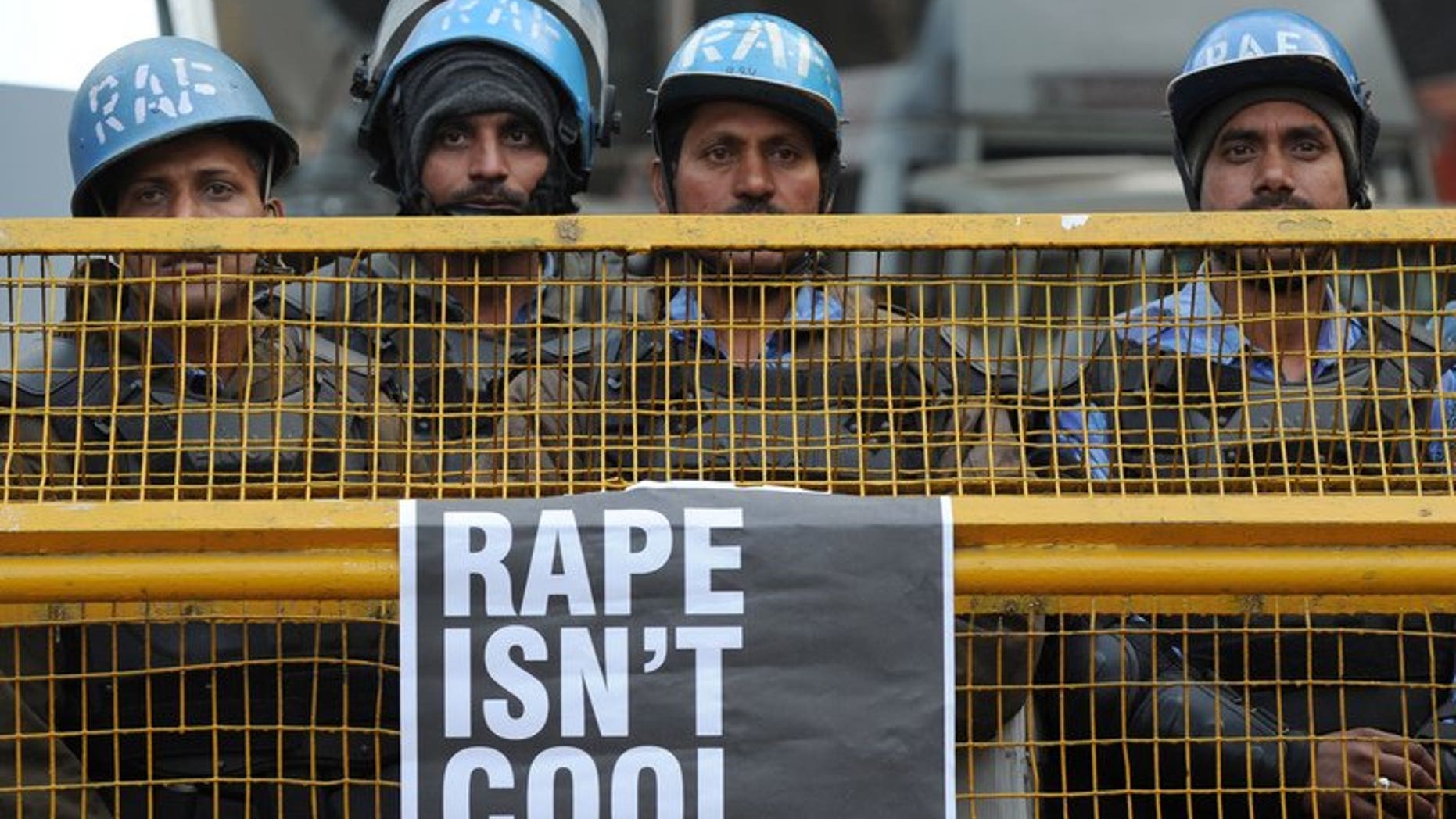 Indian Rapid Action Force personnel stand behind a barricade in New Delhi on December 31, 2012. A juveniles' court in New Delhi hearing the case of a teenager suspected of taking part in a gang-rape last December that shocked India has deferred announcing a verdict until July 25, a prosecutor said.