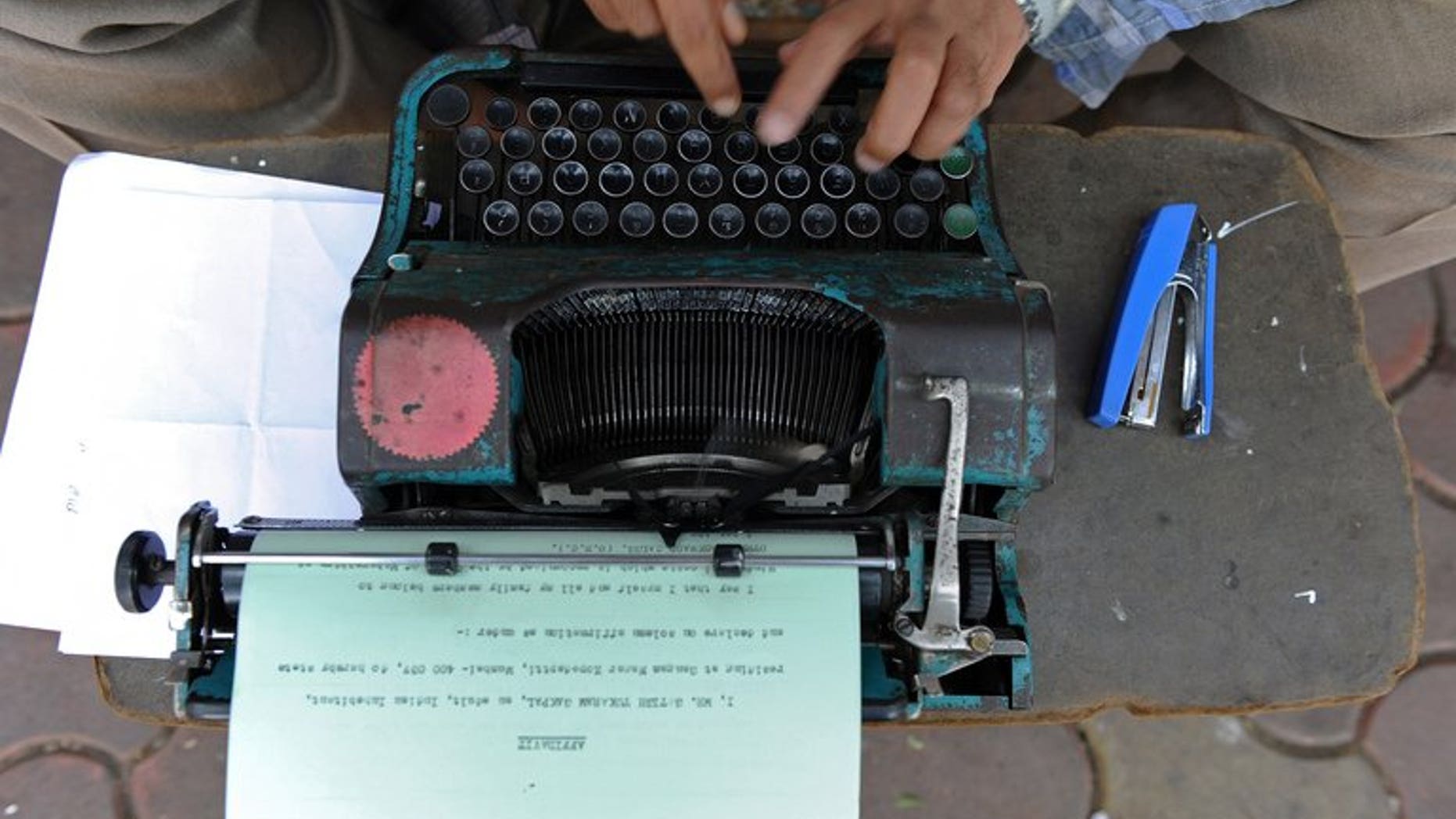An office worker types out an affidavit in Mumbai, on February 15, 2011. A Russian state service in charge of safeguarding Kremlin communications is looking to purchase an array of old-fashioned typewriters to prevent leaks from computer hardware, sources have told AFP.