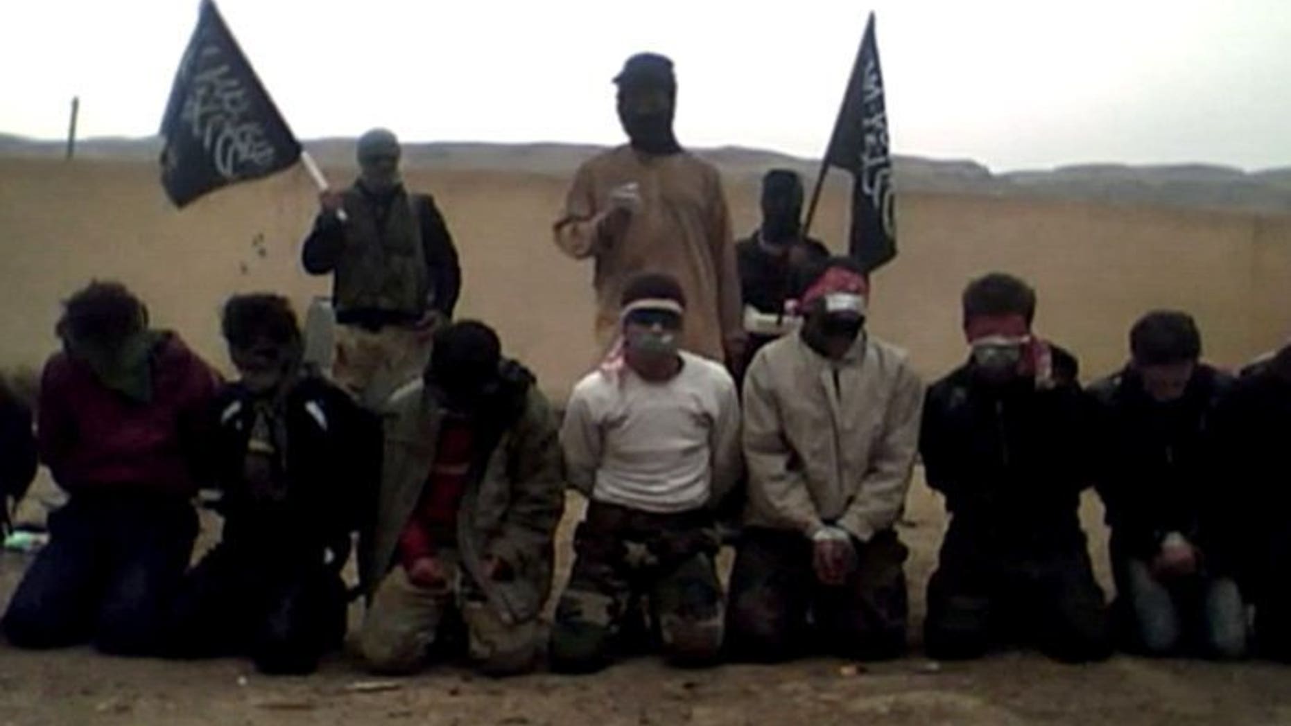Image grab taken on May 16, 2013 from a video uploaded on YouTube allegedly shows a member of the jihadist Al-Nusra Front delivering a statement before shooting blindfolded supporters of the Syrian regime at an undisclosed location in eastern Syria. There are two main Al-Qaeda linked factions in Syria, according to Washington: the Al-Nusra Front and the Islamic State of Iraq and Syria (ISIS).
