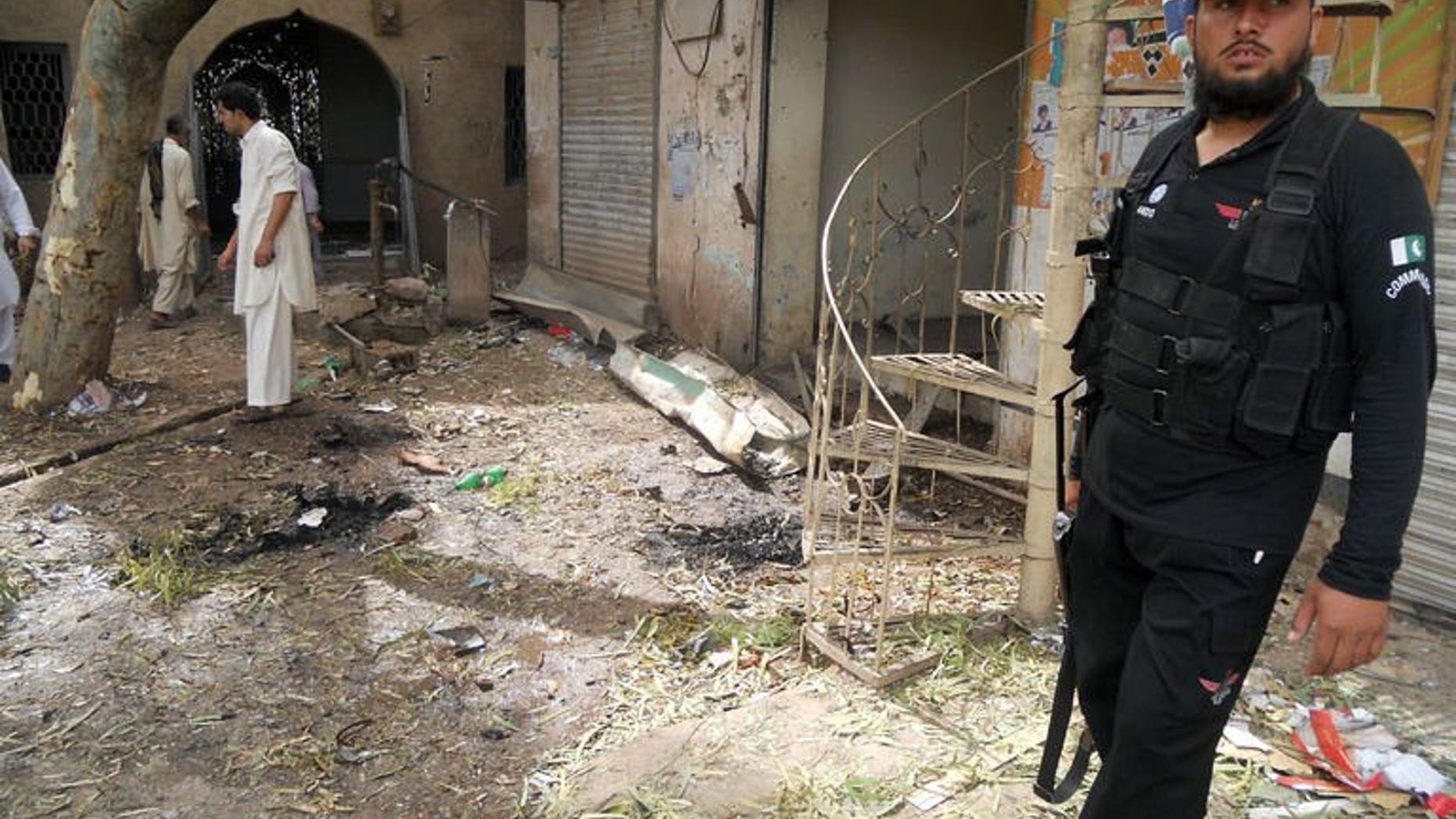 A Pakistani policeman stands at the site of a motorcycle bomb explosion in the northwestern province of Khyber Pakhtunkhwa, on July 11, 2013. At least two people were killed and five others wounded when a motorcycle bomb exploded at a roadside restaurant in northwest Pakistan.