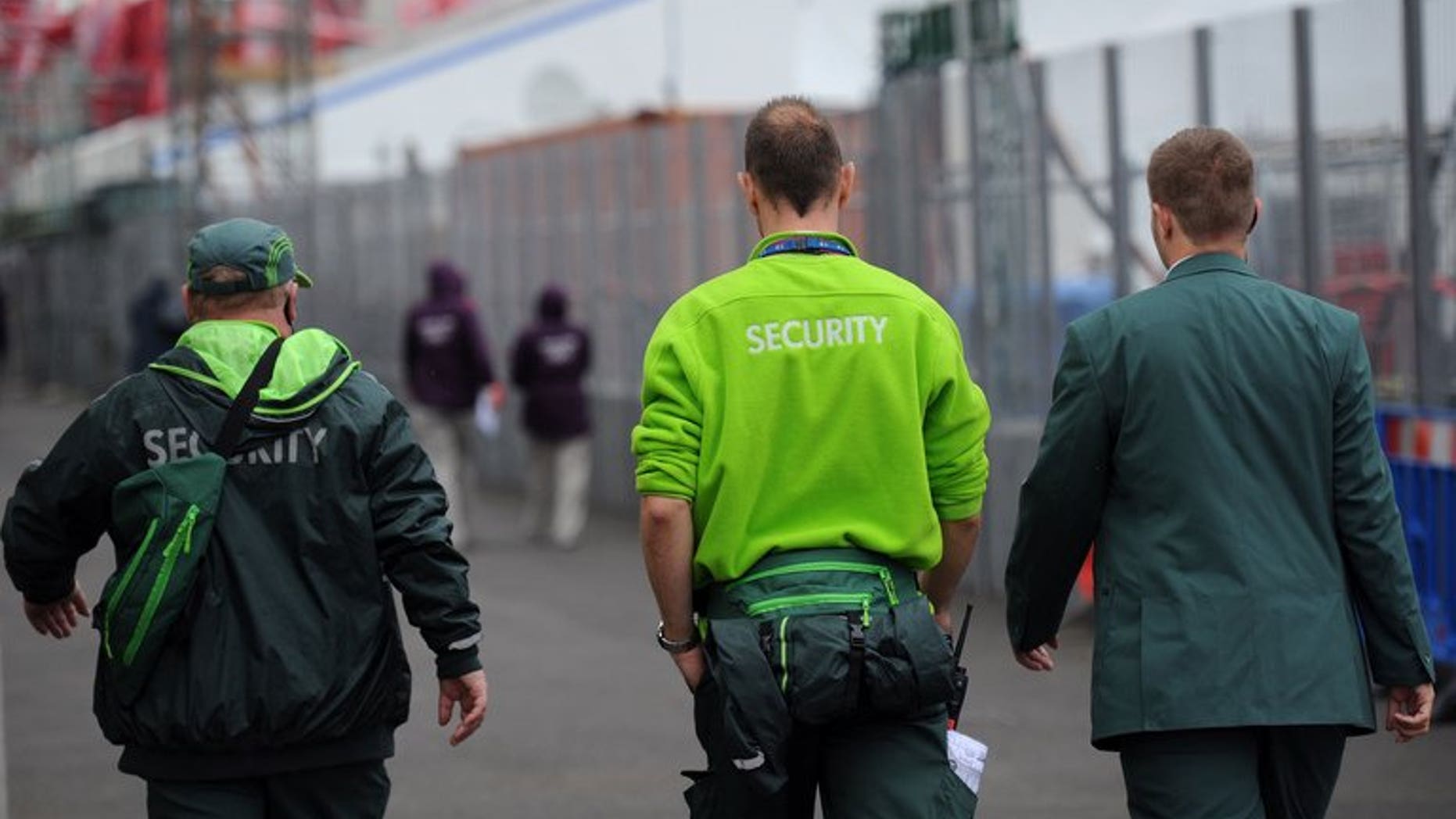 Security guards from the private firm G4S walk through the London 2012 Olympic Park in east London on July 18, 2012. The security giants G4S and Serco overcharged the government by tens of millions of pounds for the electronic tagging of criminals, including claiming they were tagging people who had died, the justice secretary said Thursday.