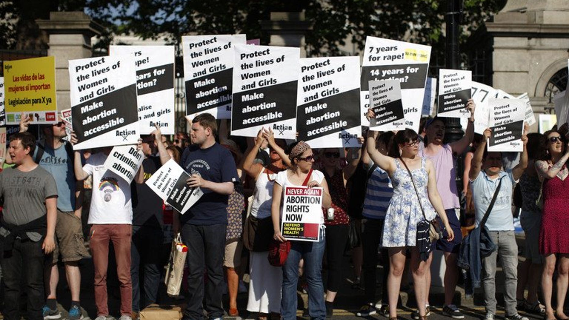 Abortion rights supporters hold placards in front of the gates of the Irish Parliament building in Dublin on July 10, 2013. Irish lawmakers on Friday voted in favour of controversial new legislation which will allow for abortion in limited cases where the mother's life is at risk, broadcaster RTE announced.