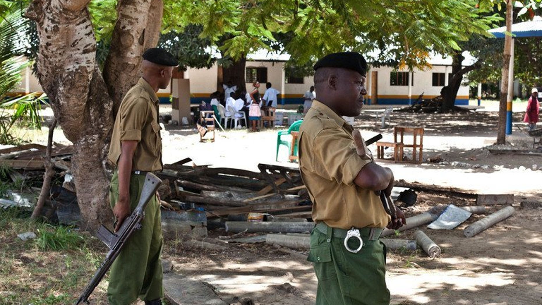 File picture shows police officers on guard at a polling station in Kakuyuni in the coastal Kenyan town of Malindi on February 24, 2013. Three foreigners facing terrorism charges at home have been charged with illegally entering Kenya and are set to be deported, lawyers and officials said Friday.