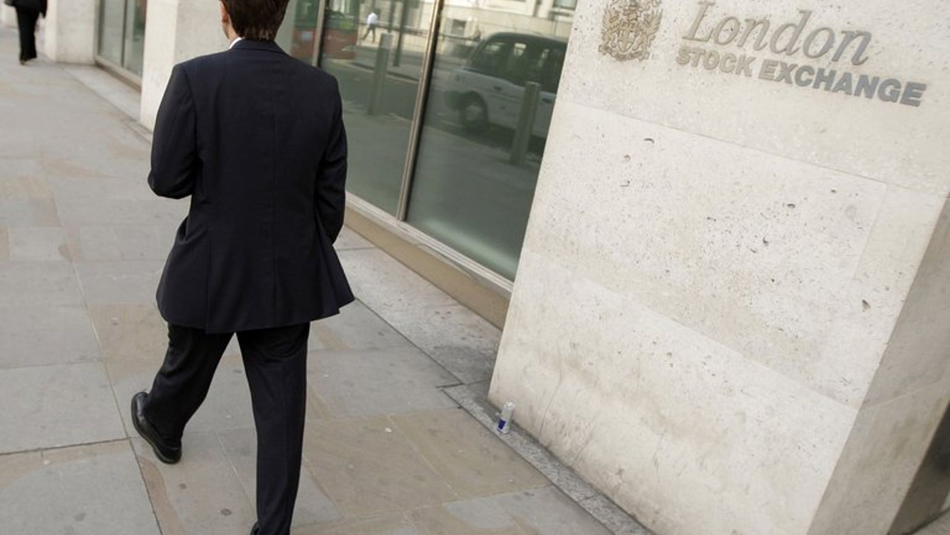 City workers walk past the London Stock Exchange. London shares closed flat on Friday as higher inflation data in the US dampened confidence slightly after Thursday's strong rise, dealers said.