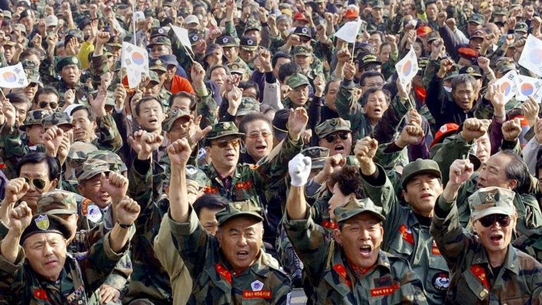 South Korean Vietnam War veterans shout slogans during a rally near the National Assembly in Seoul, October 29, 2004. South Korea's highest court on Friday upheld a ruling ordering two US Agent Orange makers to compensate 39 Vietnam War veterans, while sending another decision back to a lower court for review.
