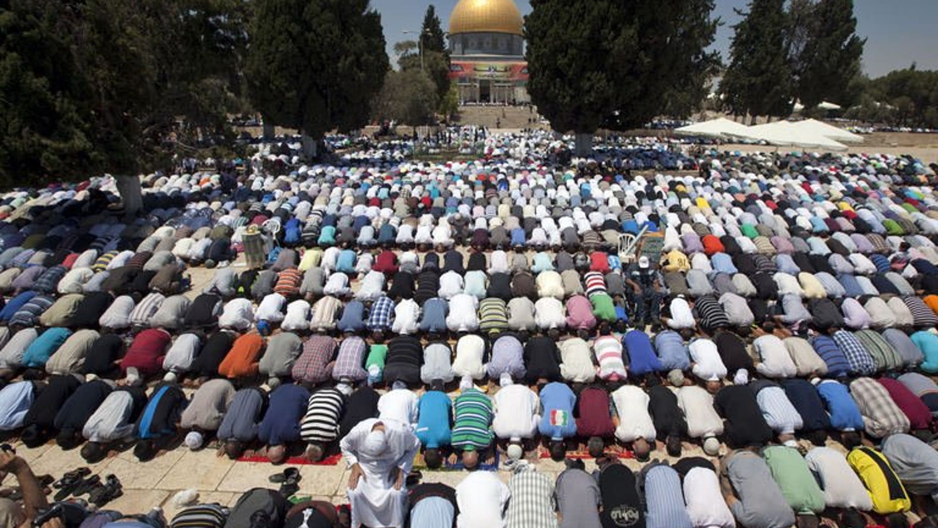Palestinian worshipers pray outside the Dome of the Rock at the Al-Aqsa Mosque compound in Jerusalem during the first Friday prayers of the Muslim holy fasting month of Ramadan on July 12, 2013.