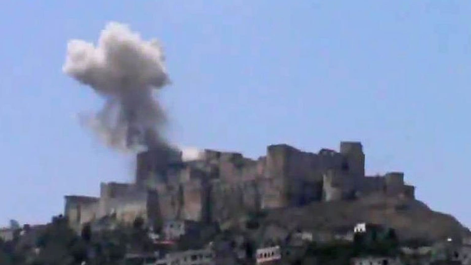 An image grab taken from a video uploaded on YouTube on July 12, 2013 shows smoke billowing from Syria's famed Krak des Chevaliers castle in central Homs province. AFP is using pictures from alternative sources. An air raid has damaged one of the fortress's towers, according to footage shot by activists.