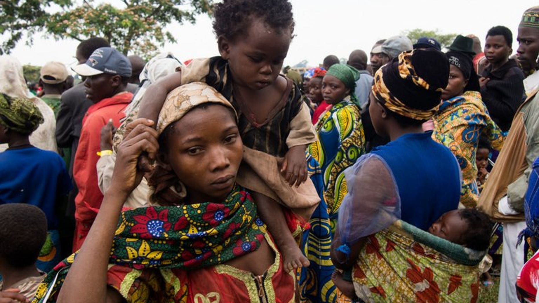 A mother carries her baby at Rwamwanja refugee camp in western Uganda on February 28, 2013. More than 30,000 refugees from eastern Democratic Republic of Congo fleeing a rebel attack on the town of Kamango have arrived in neighbouring Uganda, UN officials have said.