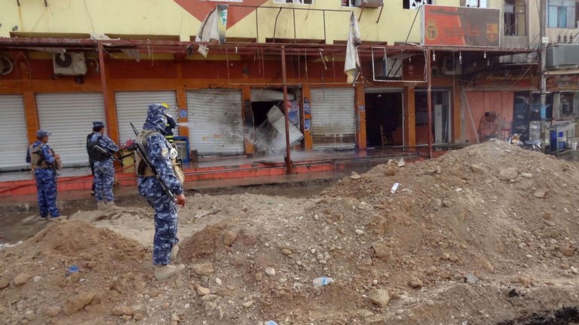 Iraqi security forces inspect the site of a suicide bombing that ripped through a crowded cafe in the northern city of Kirkuk on July 13, 2013. A suicide bombing ripped through a Shiite funeral tent in Iraq on Saturday, the second such attack in days, killing five mourners and six others died in violence elsewhere, police and medics said.