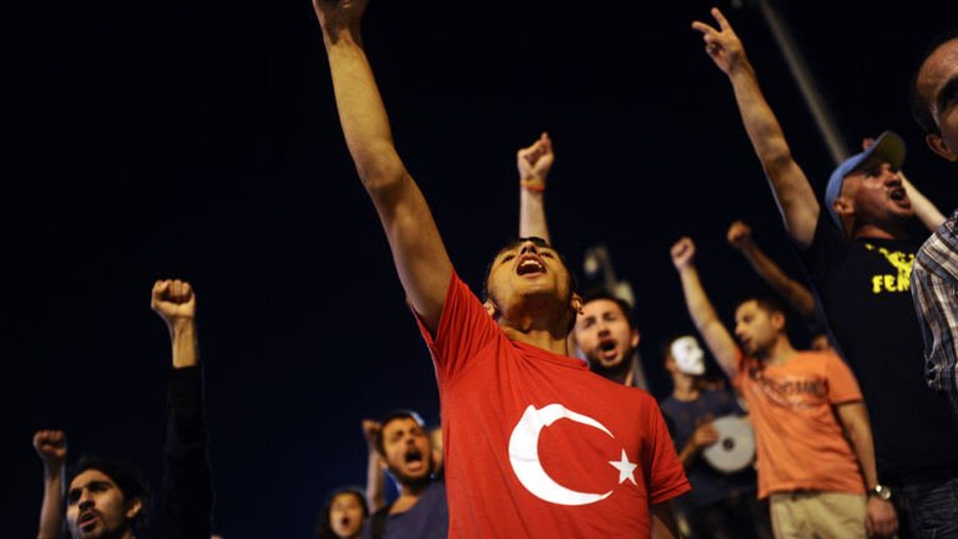 Turkish anti-government protesters shout slogans at the entrance of Gezi Park on July 11, 2013 in Istanbul. Turkish riot police on Saturday fired rubber bullets, tear gas and water cannon to disperse hundreds of protesters trying to enter an Istanbul square that was the cradle of deadly unrest that engulfed the country in June.