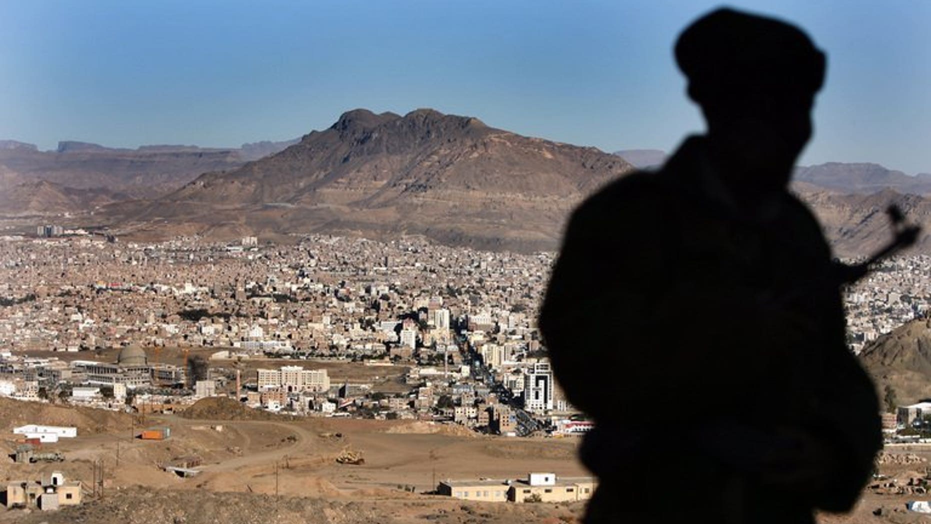 A Yemeni soldier stands on a hill overlooking Sanna, on January 13, 2010. A generator has exploded in a village home in Yemen killing 14 people, most of them members of a single family, a provincial official said.