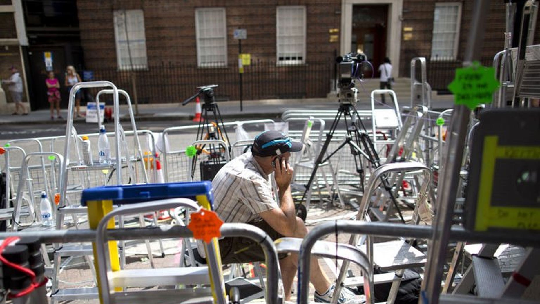 A journalist speaks on his mobile phone outside the Lindo Wing of St Mary's hospital in London, on July 13, 2013, where Prince William and his wife Catherine's baby will be born. The hospital is ready, the Wikipedia page and Twitter accounts are up and Britain's famously creative press are running out of ideas. But Sunday arrived with no sign of the royal baby.