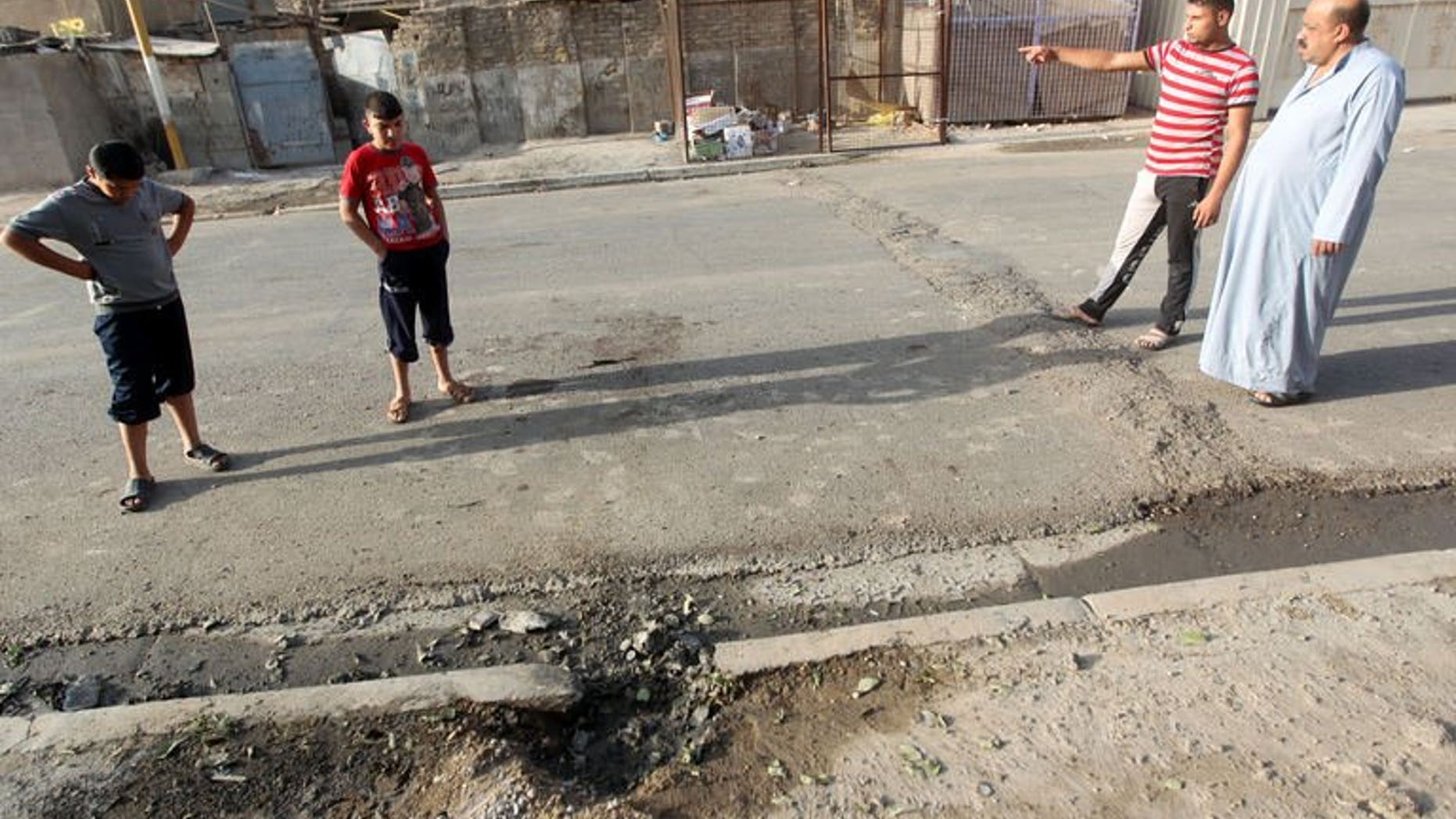 Iraqi's inspect a crater after an explosion the day before in the Dura area of south Baghdad, on July 14, 2013. Violence in Iraq -- including attacks on two members of a district council in the north -- has killed eight people, officers and doctors tell AFP.
