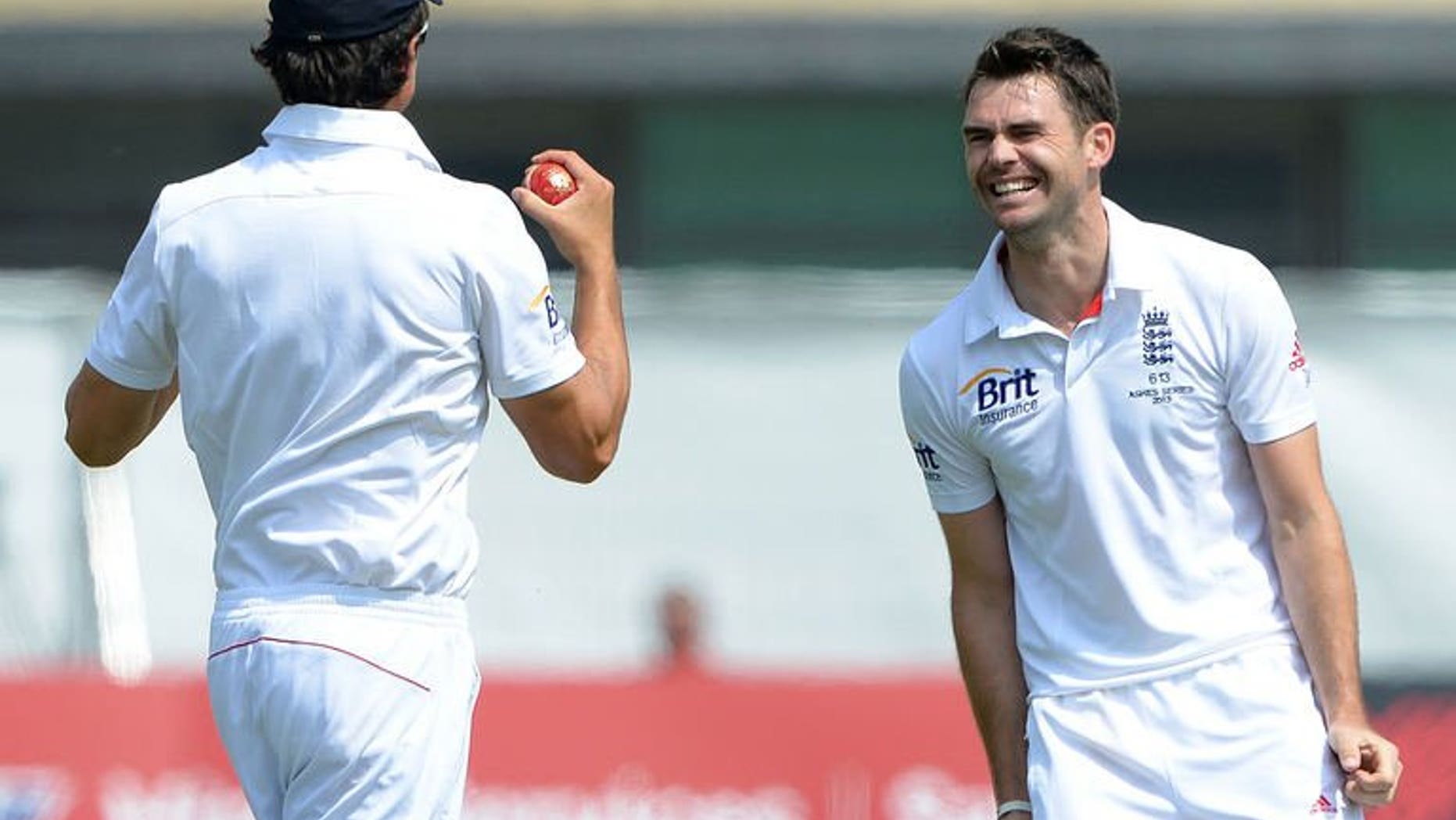 England's James Anderson (R) celebrates with England's Alastair Cook after claiming the wicket of Australia's Mitchell Starc during the fifth day of the first Ashes cricket test match between England and Australia at Trent Bridge in Nottingham, central England, on July 14, 2013.