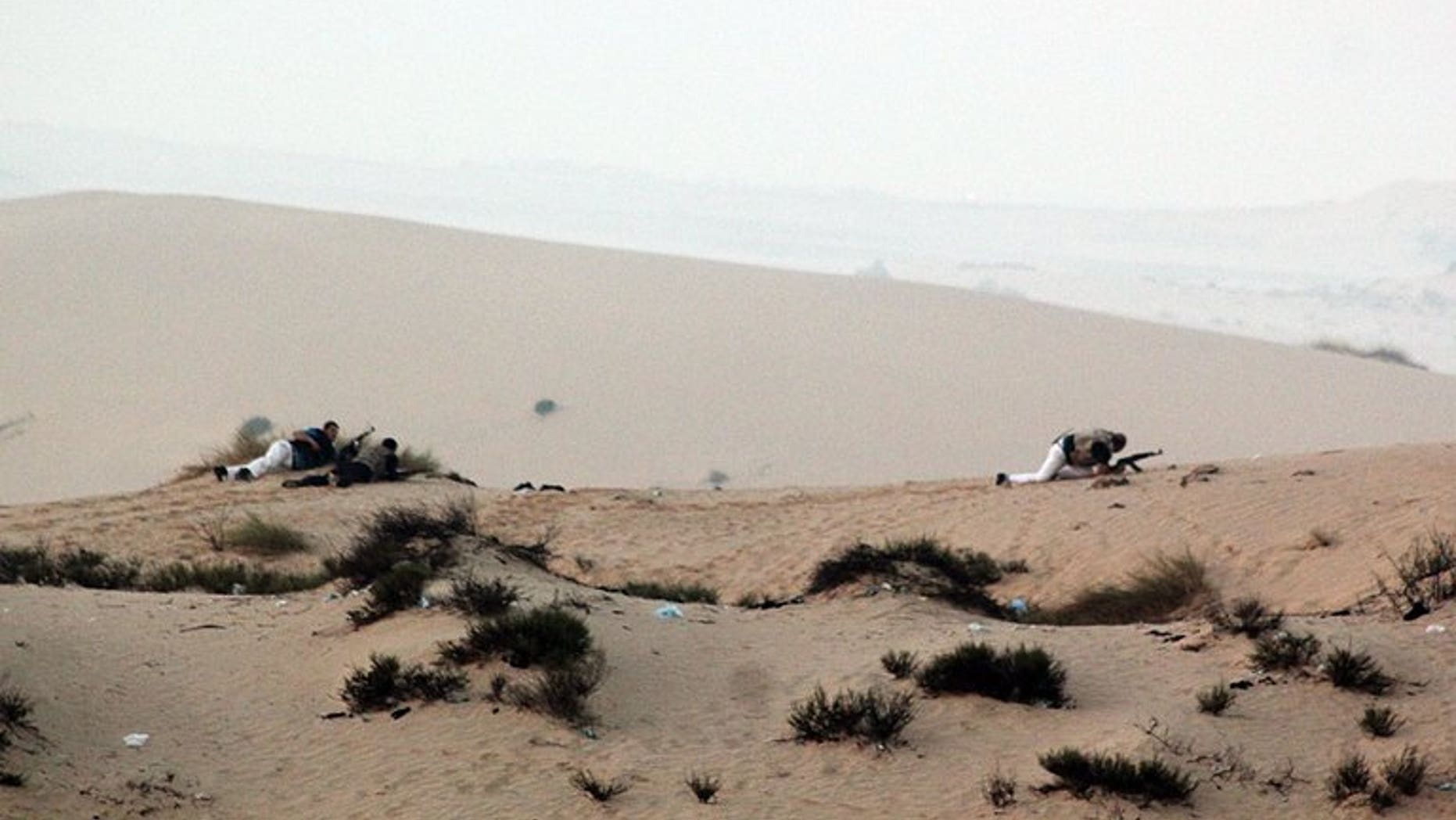 Egyptian security forces take position on a sand dune during an operation in the northern Sinai peninsula on August 8, 2012. Gunmen clashed with the Egyptian army on Sunday near the Israeli border, security sources said, in the latest violence to erupt in the Sinai peninsula since the ouster of president Mohamed Morsi.