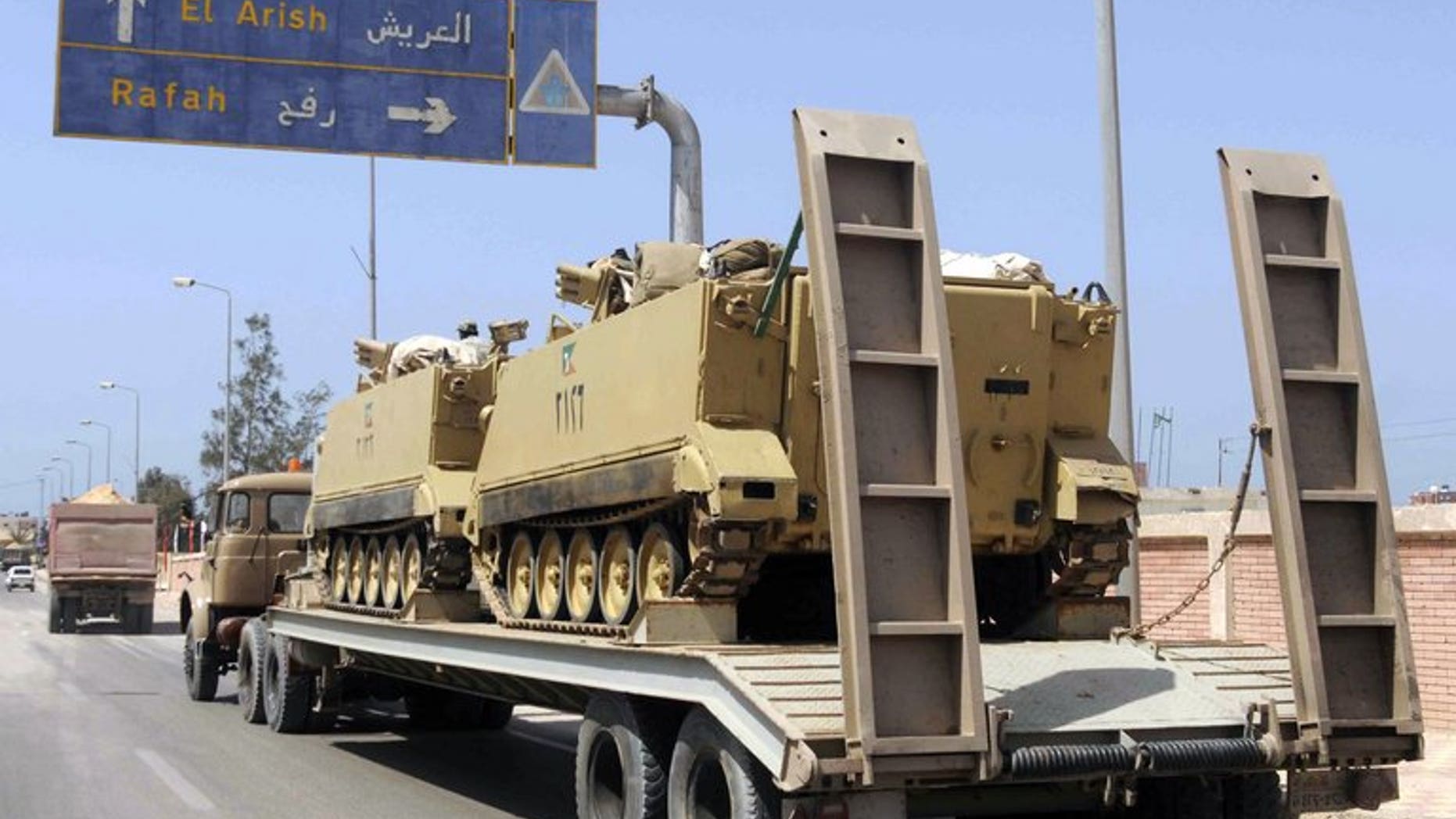 An Egyptian military truck carries armoured personnel carriers towards Al-Arish, in the northern Sinai on May 20, 2013. Militants killed at least three people Monday and wounded 17 when they fired on a bus carrying workers in Al-Arish, security and medical sources said.