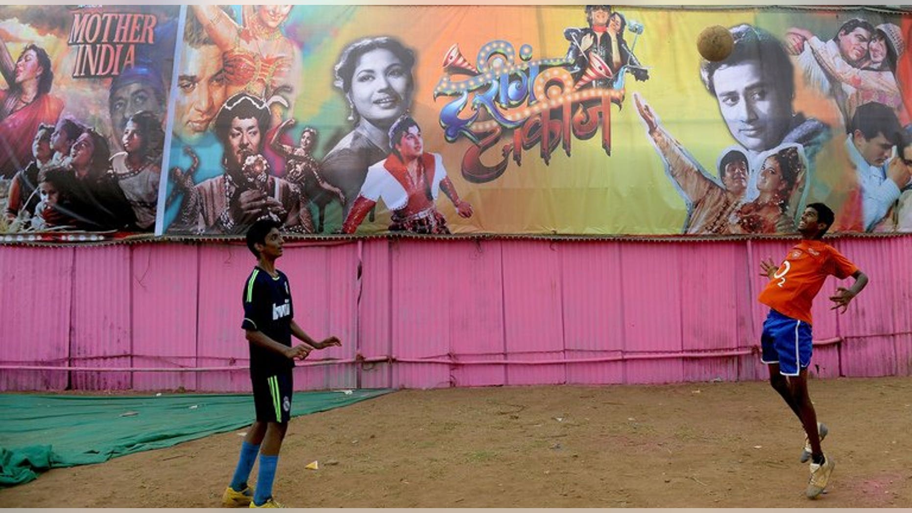 Two boys play football in central Mumbai on April 19, 2013. India's top football clubs have hit out at the national federation over moves to stage a cash-rich franchise-based tournament inspired by cricket's popular Indian Premier League early next year.