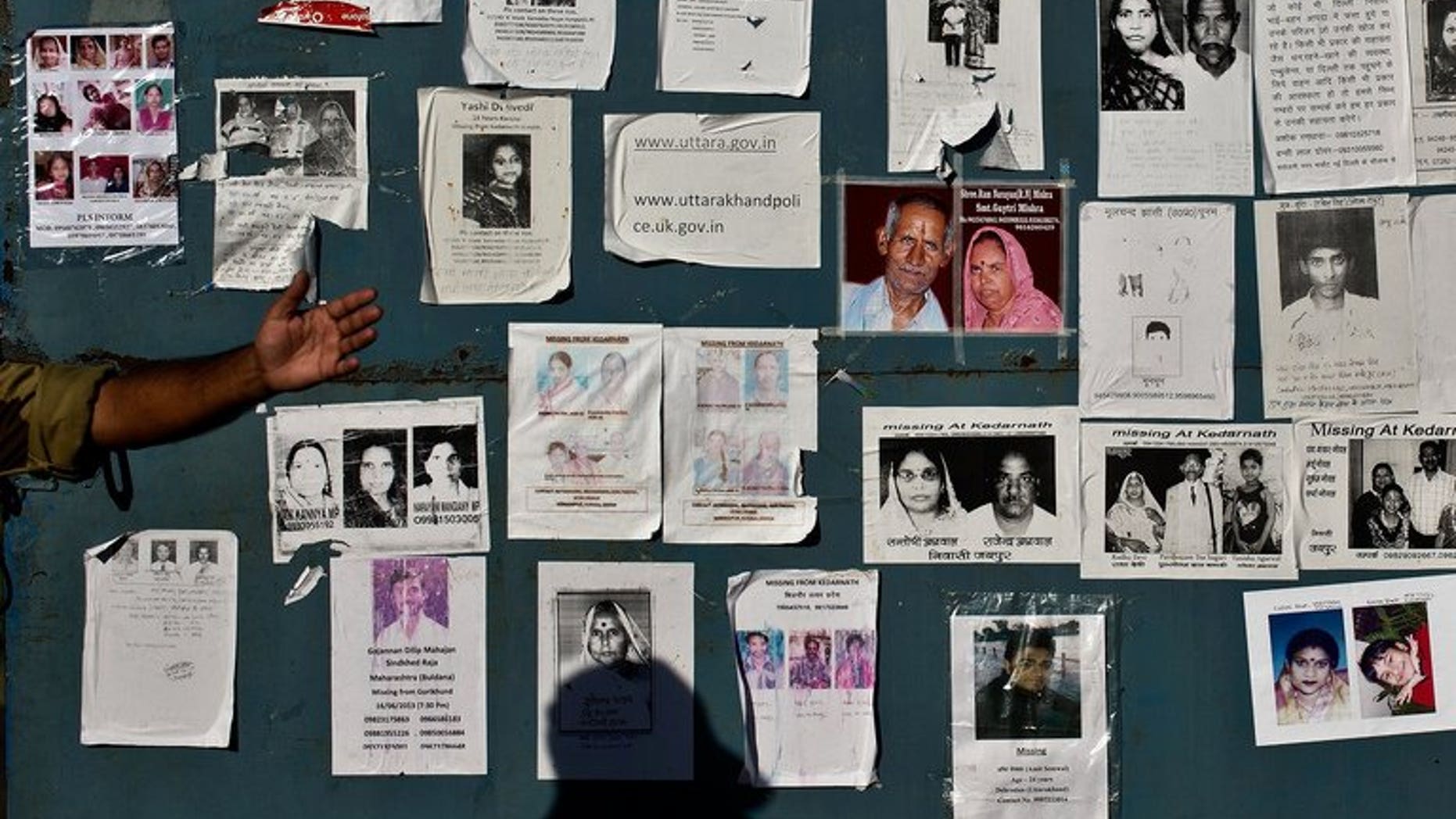 Portraits of people missing after devastating floods hit the northern state of Uttarakhand are pasted on the gates of the Jolly Grant Airport in Dehradun, on June 26, 2013. Almost 6,000 people listed as missing after flash floods struck northern India last month are now presumed dead, officials said.