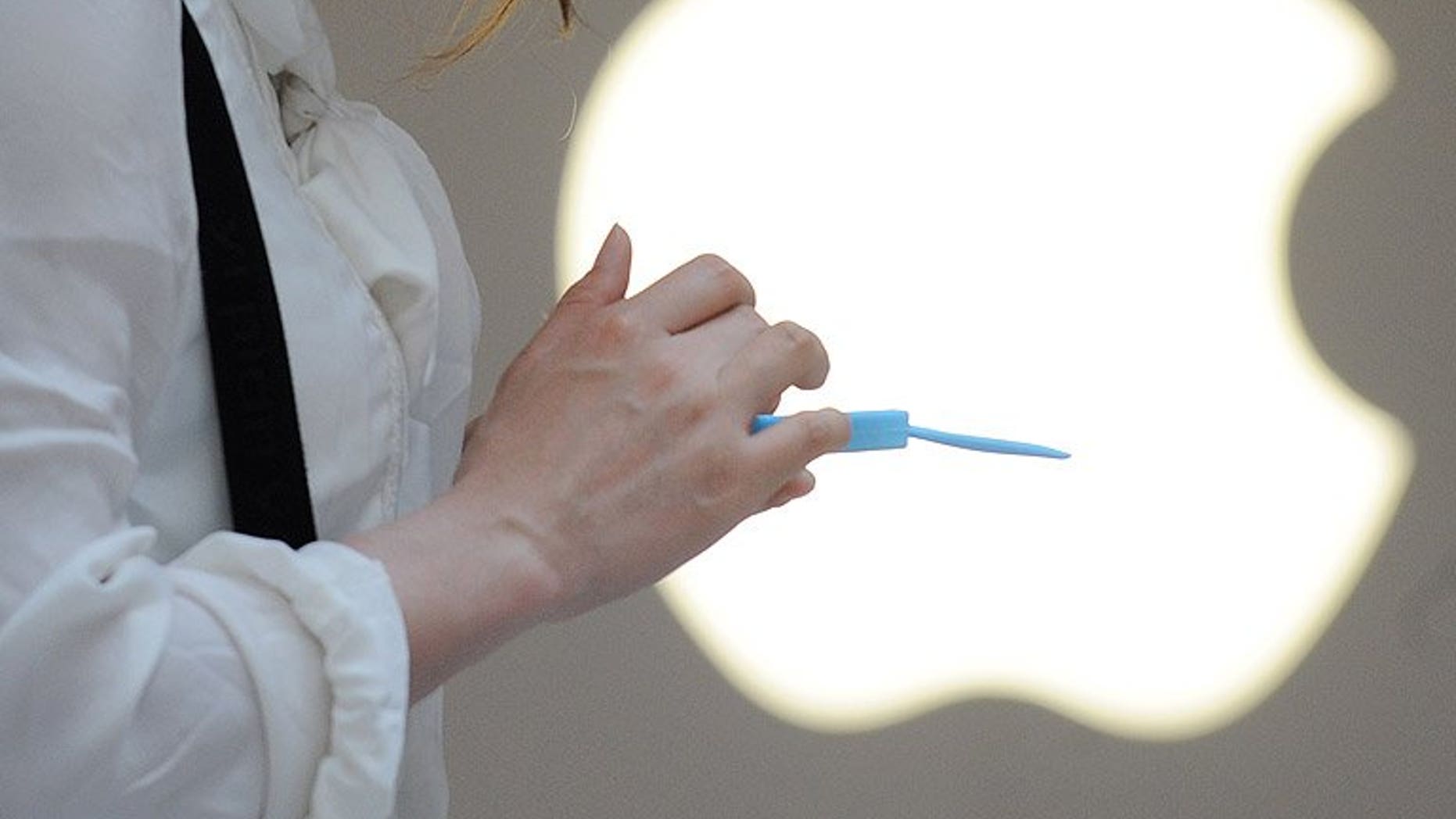 A woman uses her mobile phone outside an Apple store in Shanghai, on May 7, 2012. Apple has said it will investigate claims that an iPhone electrocuted a Chinese woman who was making a call while charging the device.