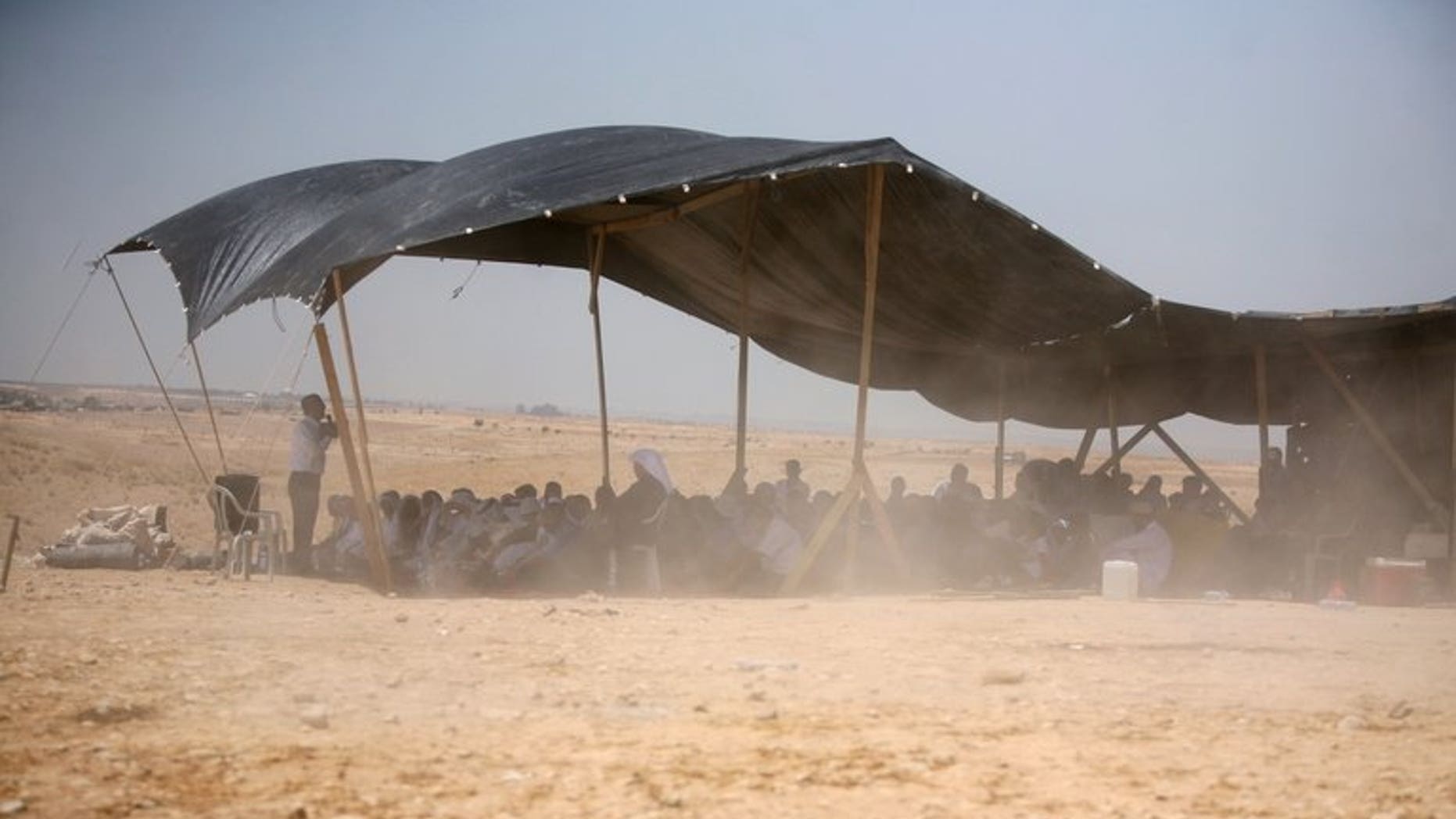 Bedouins attend Friday prayer under a tent in the Al-Araqib village located between Beersheba and Rahat in the Israeli Negev desert on May 14, 2010. Israeli police said they detained 15 Bedouin as hundreds of the tribesmen and women marched in the city of Beersheba to protest a government plan to resettle them.