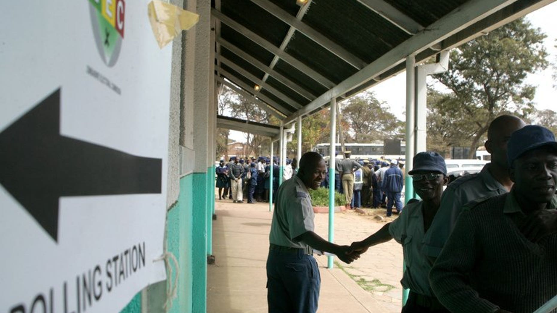 Police officers queue outside a polling station to vote during the special voting day for registered members of the police and army in Harare on July 14, 2013. Local election monitors called Monday for Zimbabwe to extend early voting for thousands of police officers and warned the country's electoral system was in disarray two weeks from a crucial presidential poll.
