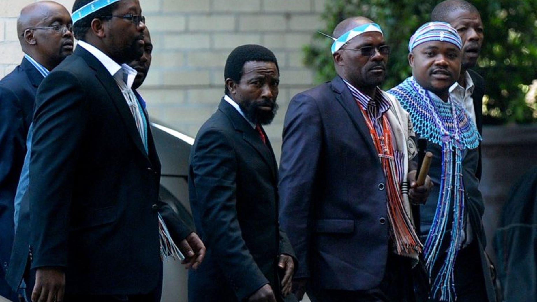 Thembu King Buyelekhaya Dalindyebo (C), flanked by chiefs, arrives on July 9, 2013 to visit former South African president Nelson Mandela at the Medi Clinic Heart Hospital in Pretoria. Dalindyebo defected from the ruling ANC to join the Democratic Alliance (DA) Monday, days after launching a fierce attack on President Jacob Zuma.