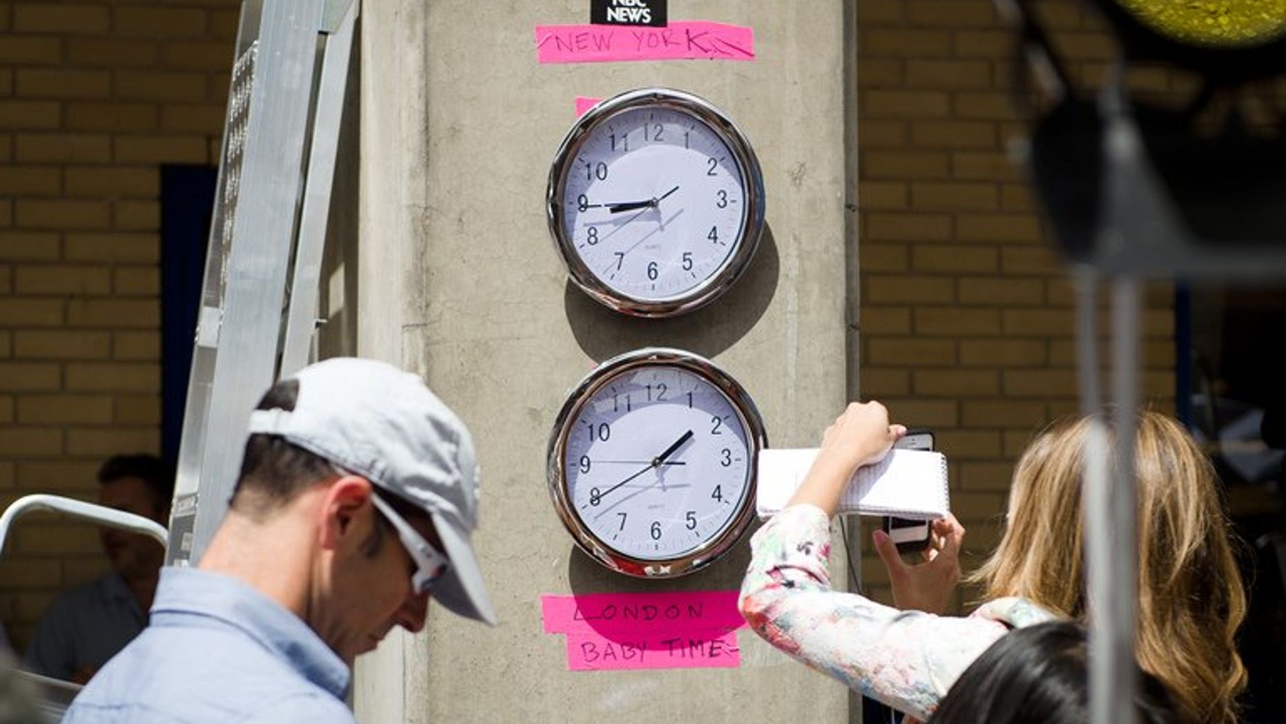 Clocks showing New York and "London Baby Time" are hung on a wall in the media pen outside the Lindo Wing of Saint Mary's Hospital in London, on July 15, 2013.