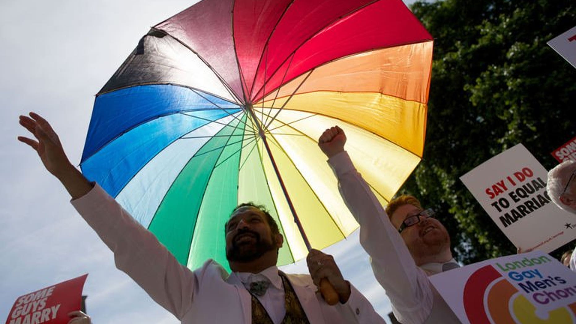 Gay campaigners rally outside the Houses of Parliament as the Marriage (Same Sex Couples) Bill gets an unopposed third reading by the Lords in central London on July 15, 2013. The first gay marriages in England and Wales are set to take place in 2014 after the legislation passed through parliament's upper chamber the House of Lords on Monday.