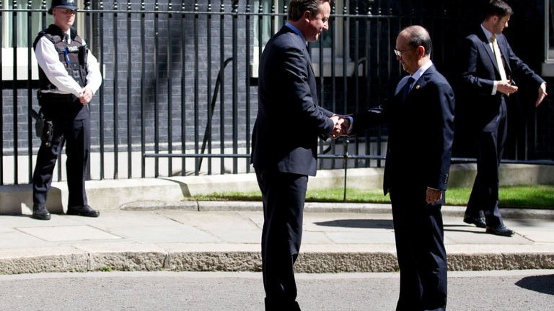 British Prime Minister David Cameron (L) greets Myanmar President Thein Sein ahead of a meeting at 10 Downing Street in central London on July 15, 2013. Myanmar President Thein Sein said on Monday that all political prisoners would be freed by the end of the year and that a ceasefire with ethnic groups was possible within weeks.