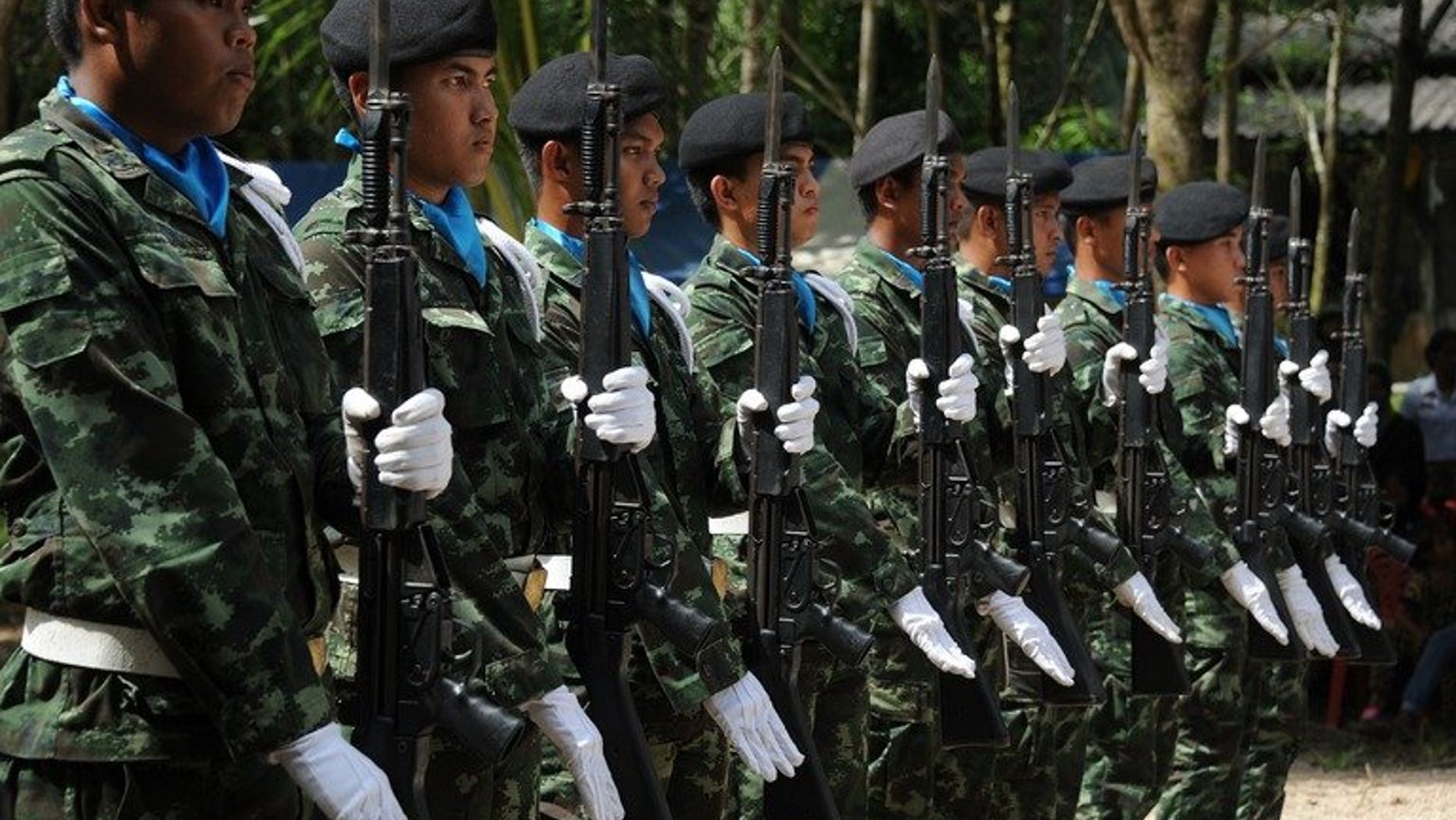 Thai soldiers raise their rifles during the funeral ceremony of a Muslim Ranger killed in an attack by suspected separatist militants in the restive southern province of Narathiwat, on June 20, 2013. Thailand is considering reducing the number of troops in its insurgency-riven south if a lull in violence holds, the deputy prime minister said on Tuesday.