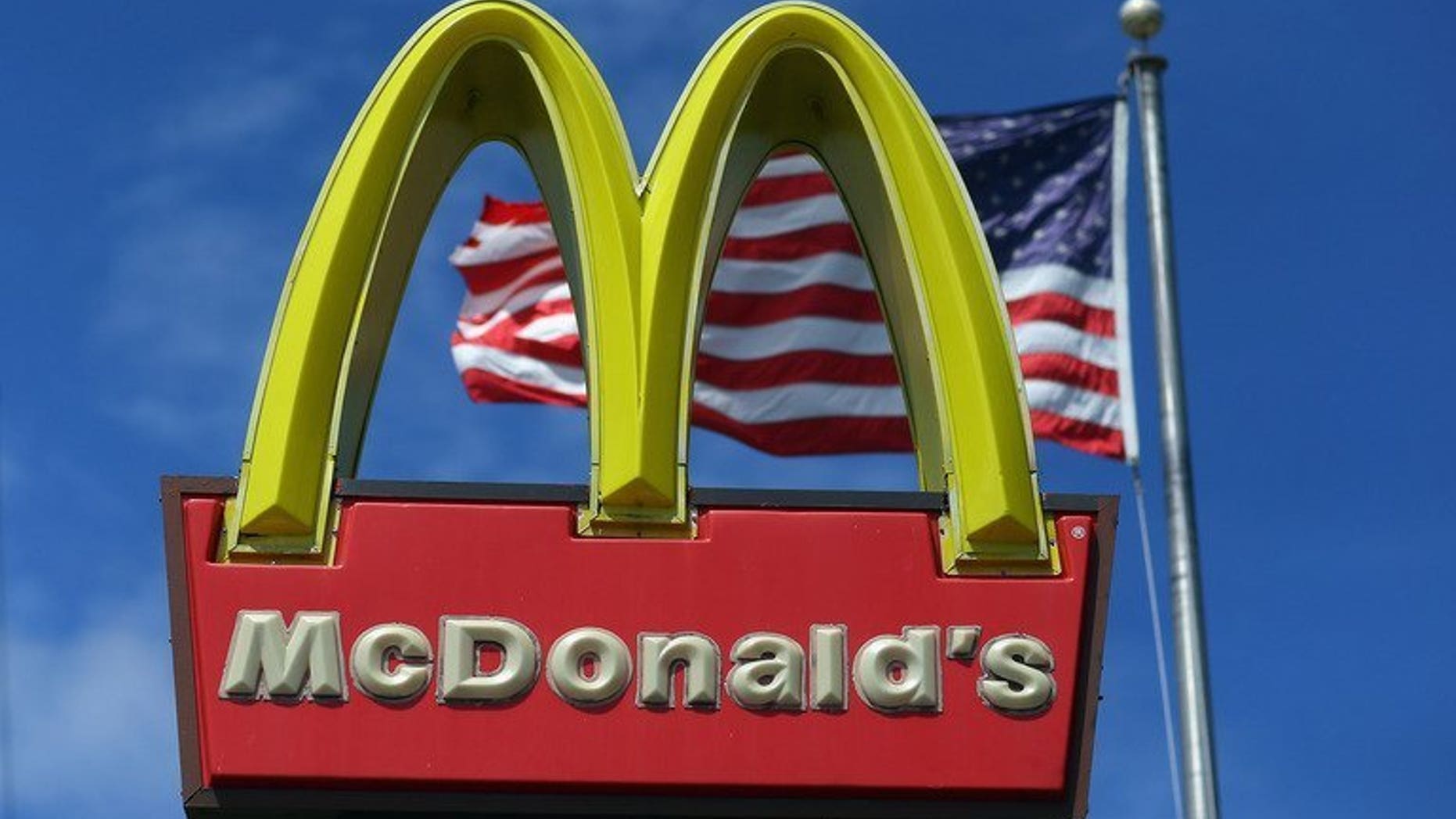 A sign for a McDonald's restaurant pictured in front of an American flag in Miami, Florida on July 23, 2012. McDonald's said Tuesday it would launch its first restaurant in communist Vietnam next year after granting a franchise to the son-in-law of Prime Minister Nguyen Tan Dung.
