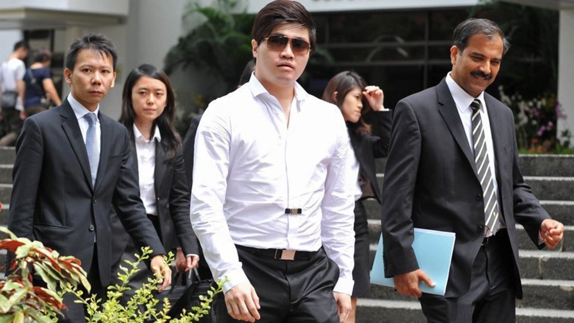 Businessman Eric Ding Si Yang (centre) leaves the district court in Singapore, on July 15, 2013. A Lebanese referee expected to be a key prosecution witness in the match-fixing trial of Ding, has admitted that the 31-year-old businessman had never asked him to rig a game.