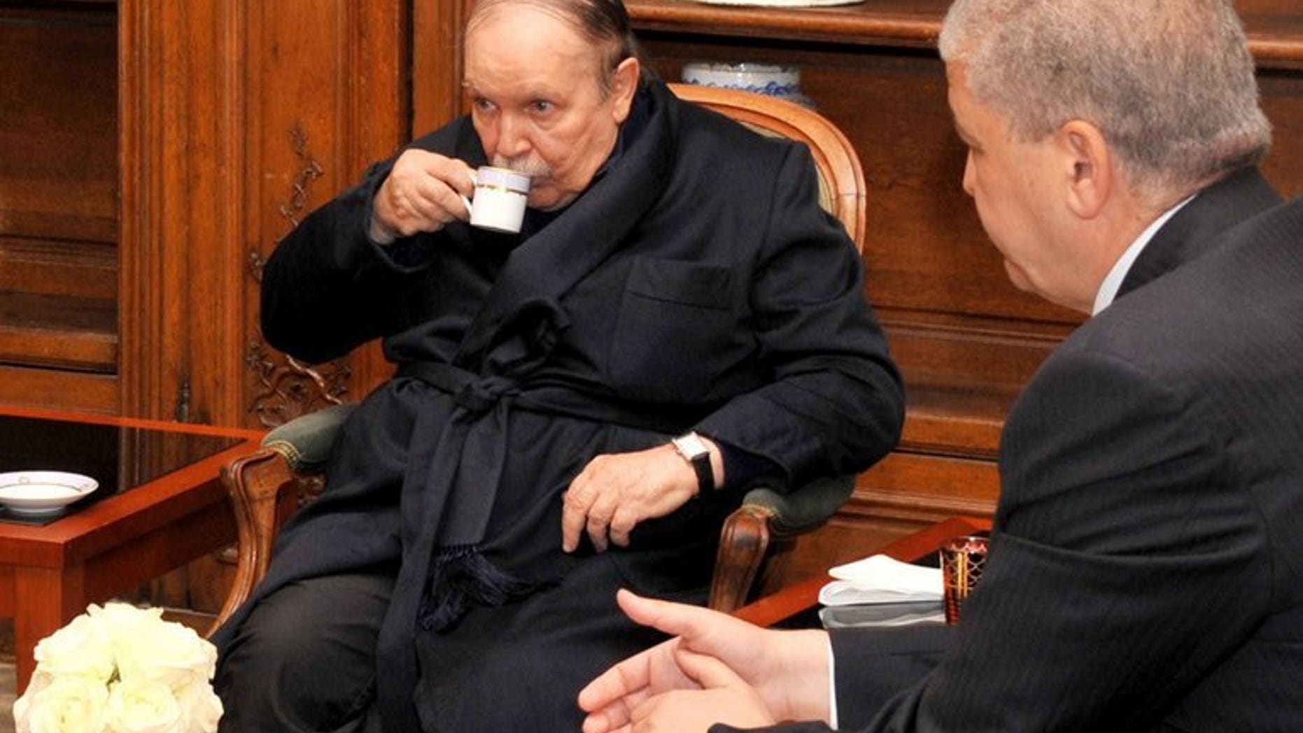 Photo obtained on June 12, 2013 from Algerian Press Service shows Algeria's President Abdelaziz Bouteflika (C) drinking tea as he receives Algeria's Prime Minister Abdelmalek Sellal (R) in a Paris hospital on June 11, 2013. Bouteflika returned home on Tuesday from Paris after a stay of almost three months in hospital that caused huge concern in the North African country, officials said.