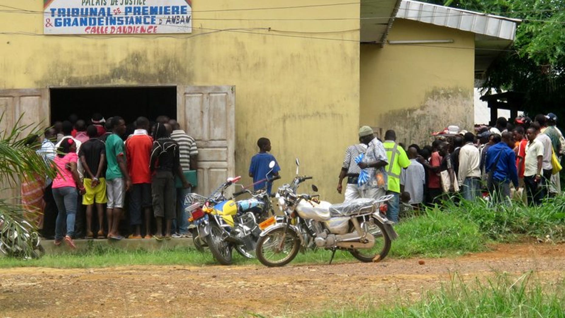 People stand in front of a tribunal in Ambam, Cameroon, during a homosexuality trial on March 15, 2012. A gay rights campaigner in Cameroon was found dead in his Yaounde home after being tortured, Human Rights Watch said on Tuesday.