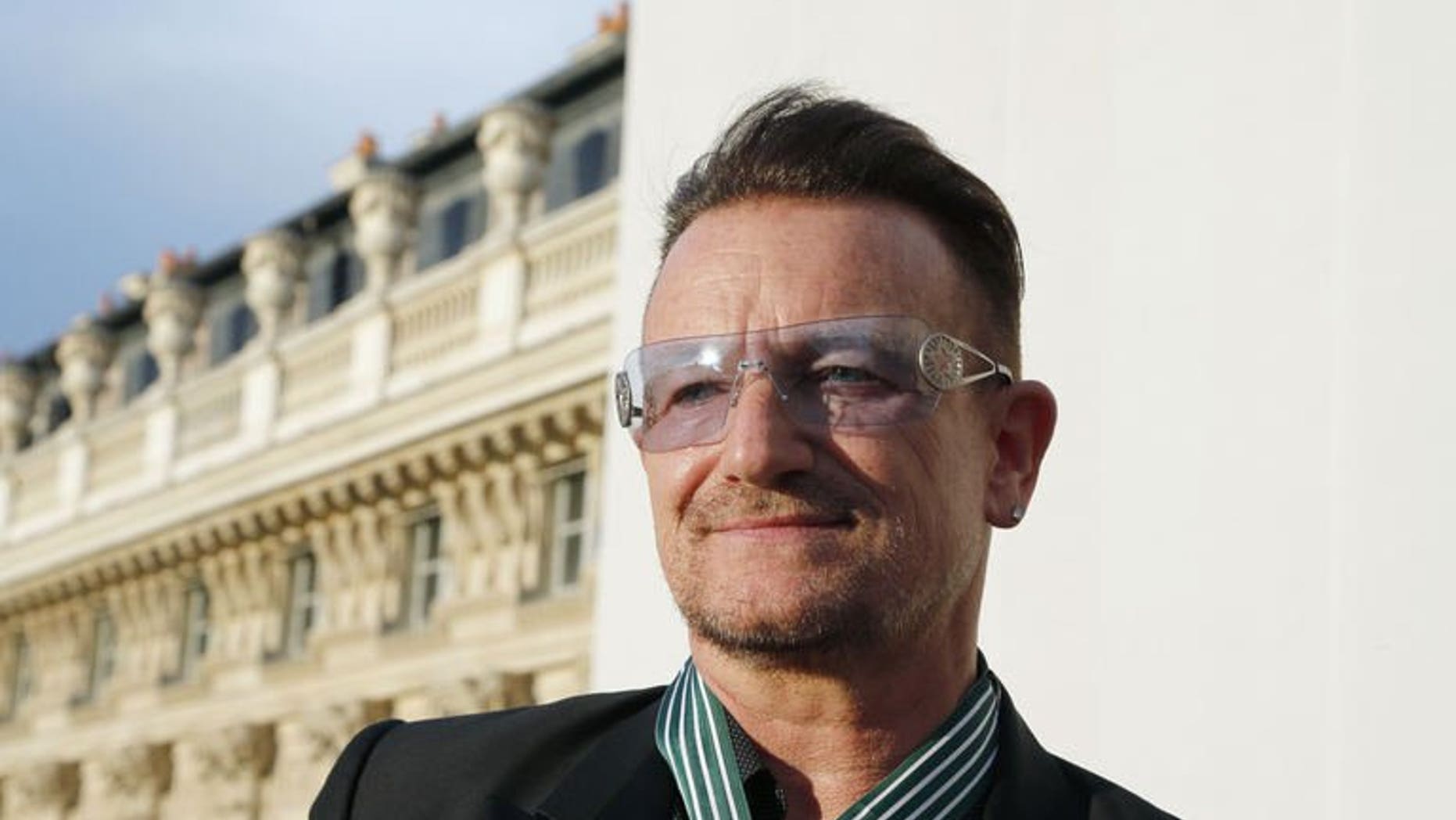 Bono, lead singer of Irish rock band, U2, poses after receiving the Commander of the Order of Arts and Letters (Commandeur de l'ordre des Arts et des lettres) insignia on July 16, 2013 in Paris.