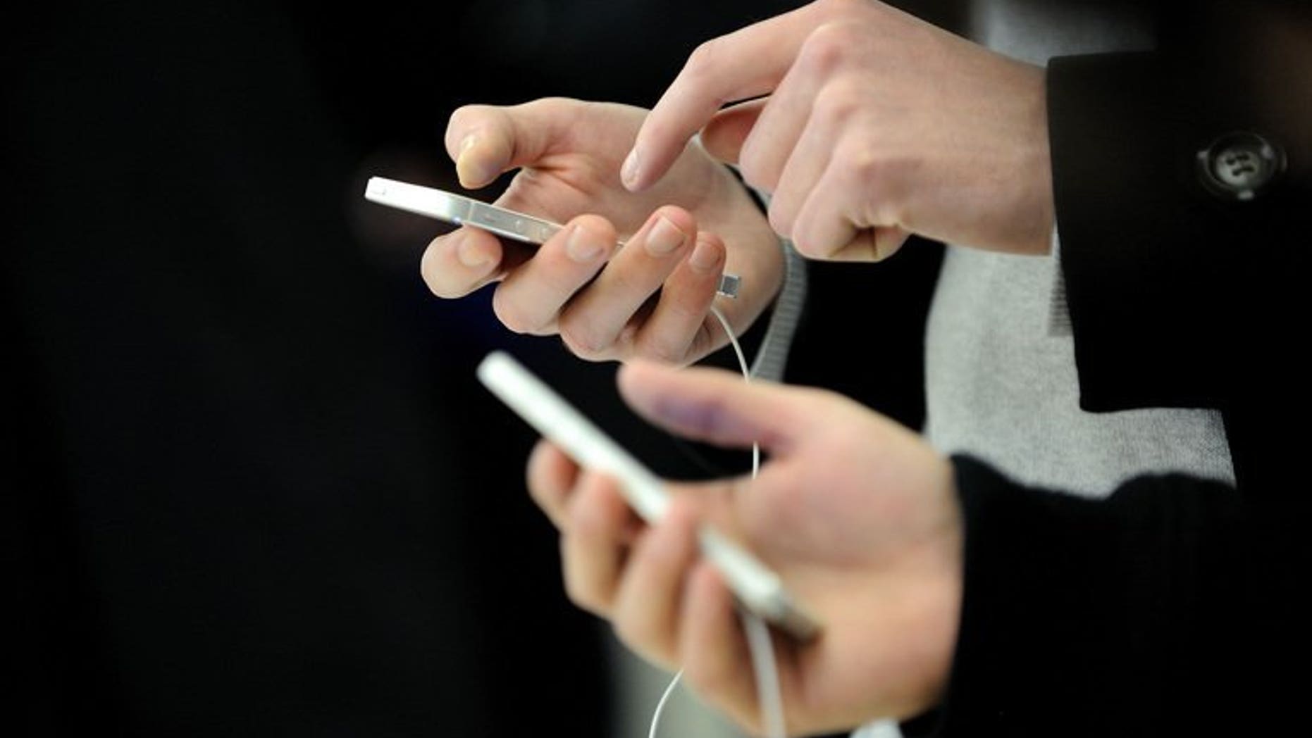 Customers are seen using Iphones during the opening of an Apple store on November 15, 2012 in Saint-Herblain, France. British scientists said they have harnessed the power of urine and are able to charge a mobile phone with enough electricity to send texts and surf the Internet.