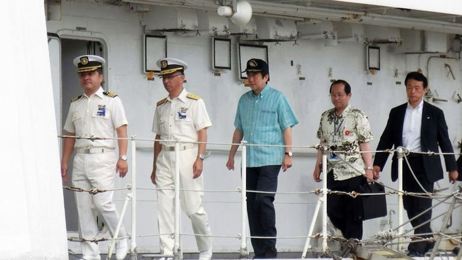 Japanese Prime Minister Shinzo Abe (C) inspects a Japan Coast Guard patrol boat off the remote Okinawan island of Ishigaki in the East China Sea, 2,000 kilometres (1,240 miles) southwest of Tokyo on July 17, 2013. Abe on Wednesday visited coastguards who patrol waters around islands at the centre of a dispute with China, as election campaigning stepped up a gear.
